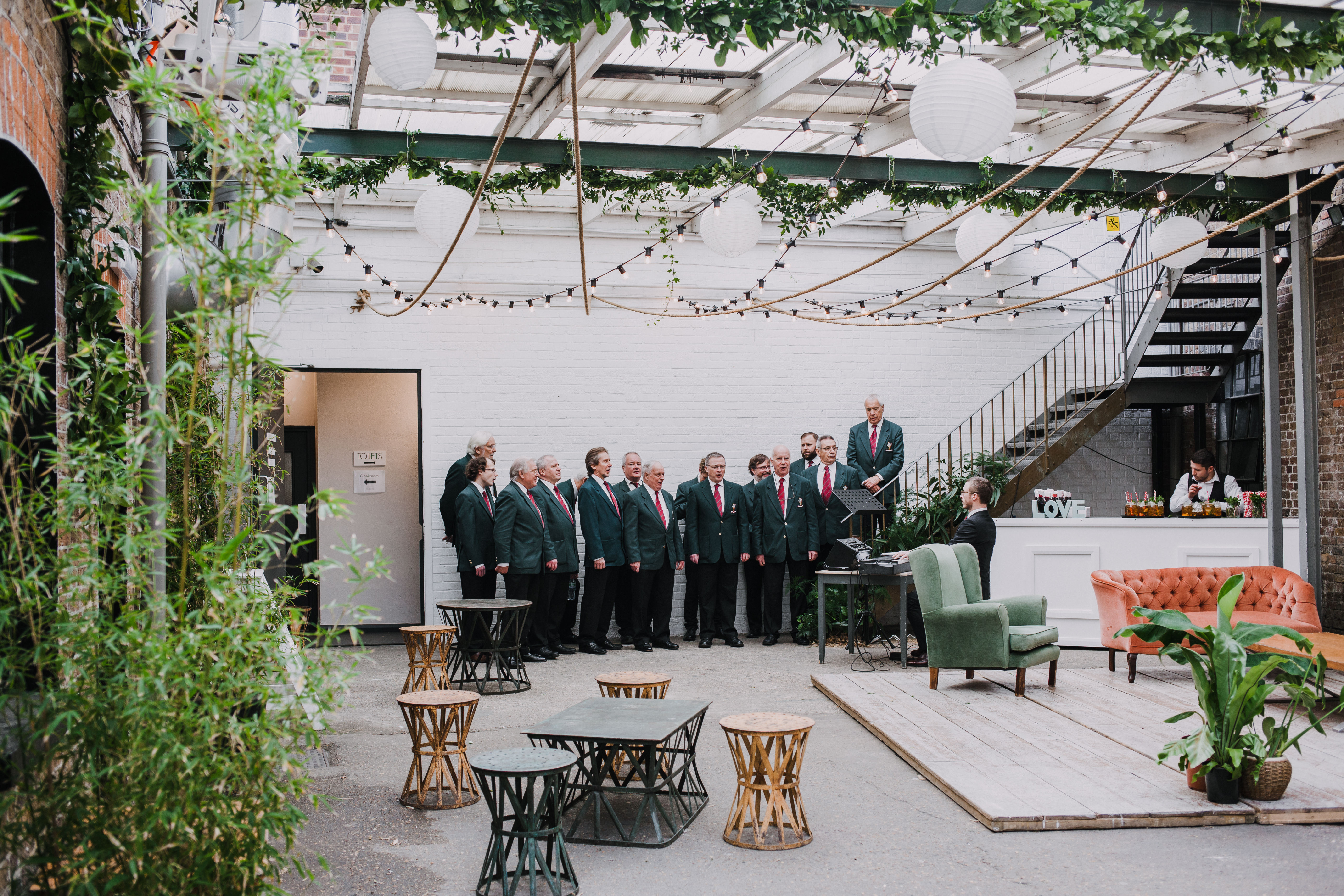 Stylish event space with greenery and lanterns at Loft Studios for presentations and gatherings.