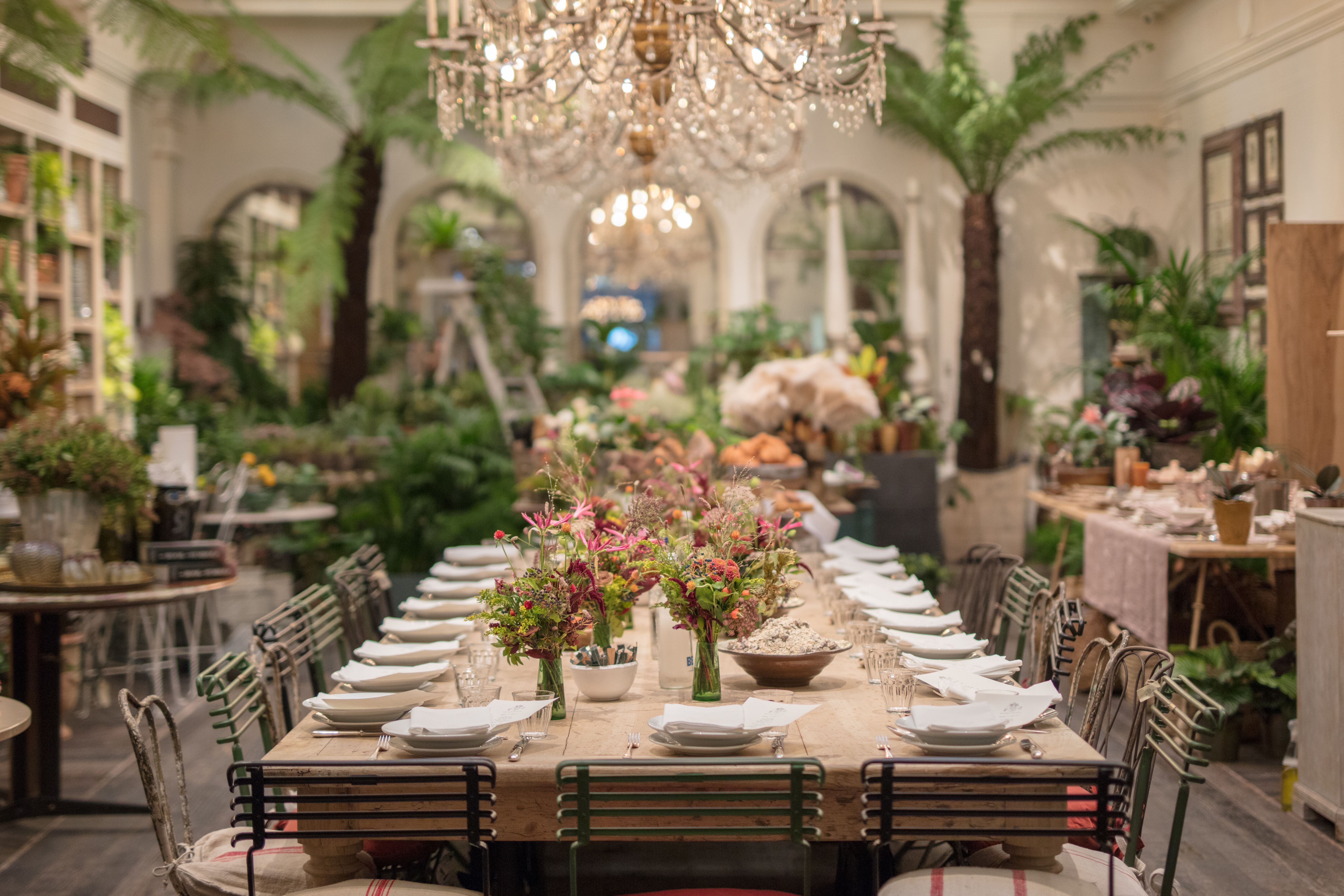 Elegant dining setup with floral centerpieces at Petersham Nurseries event space.