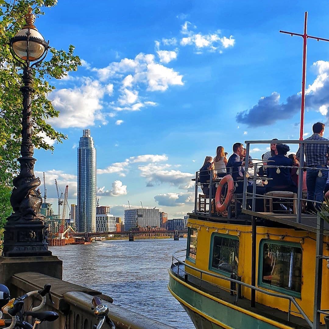Vibrant outdoor event on Tamesis Dock's West-Facing Deck with city skyline view.