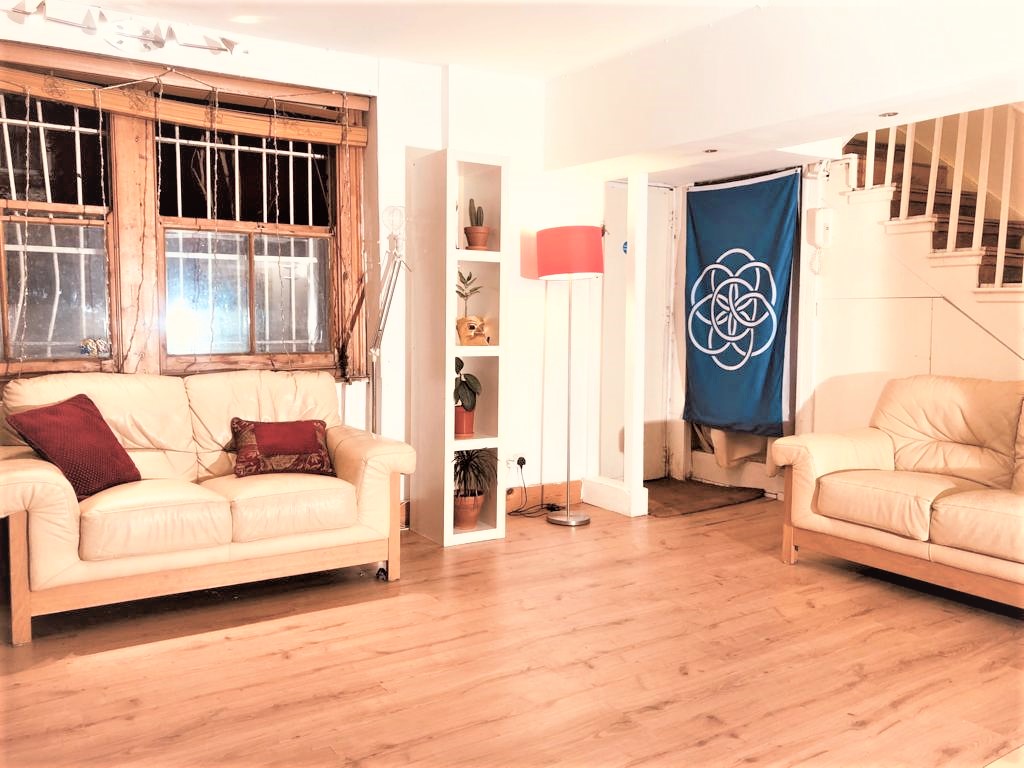 Cozy meeting space in Dalston Den with leather sofas for workshops and gatherings. - Banner