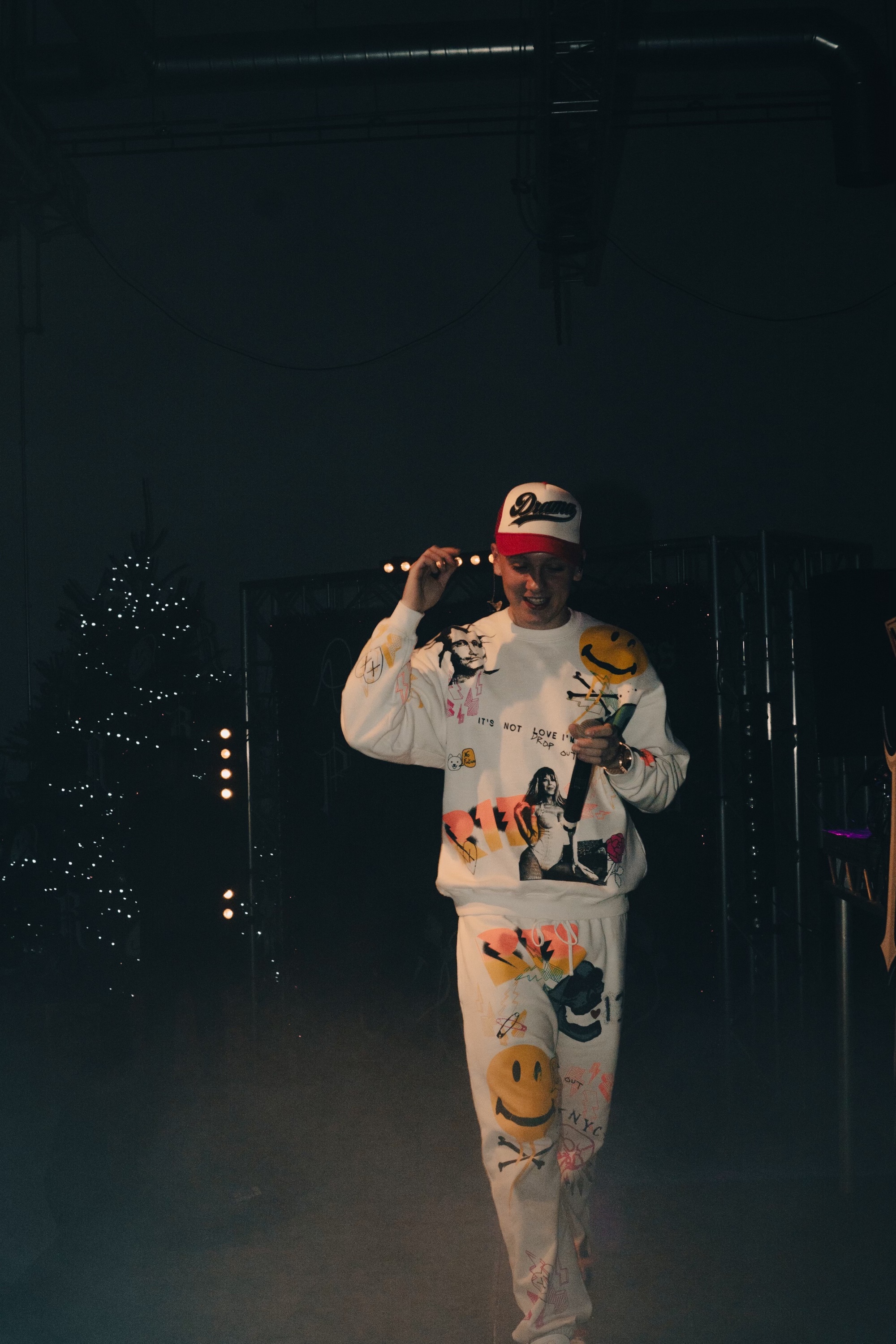 Energetic performer in vibrant attire on stage at a lively event in Studio One. - Banner