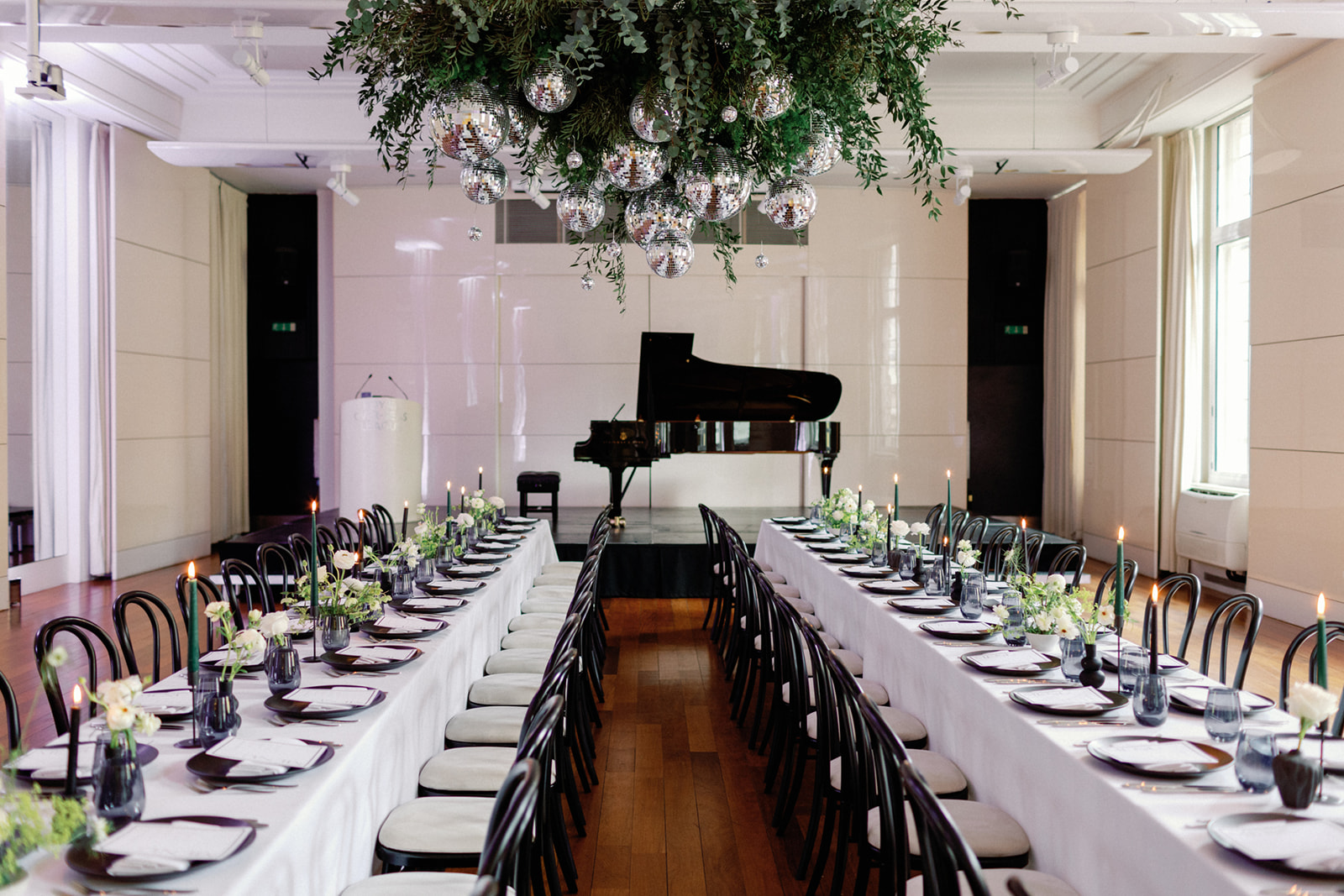 Elegant Christmas party setup with greenery, candles, and grand piano at Six Park Place. - Banner