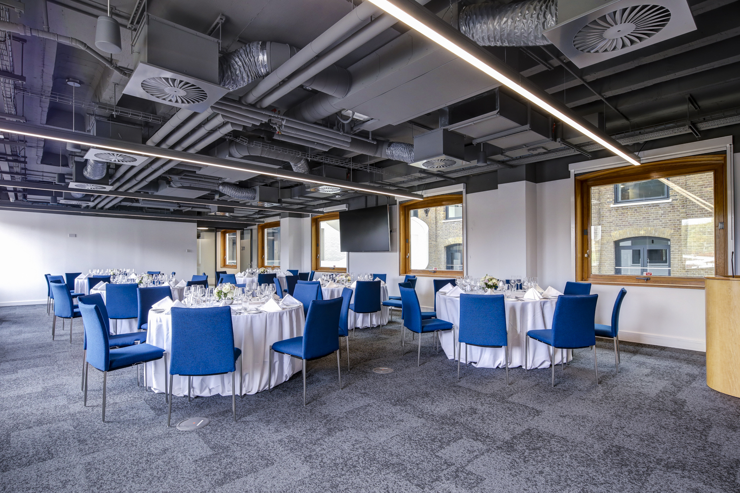 Modern event space with round tables, ideal for corporate meetings and formal gatherings.
