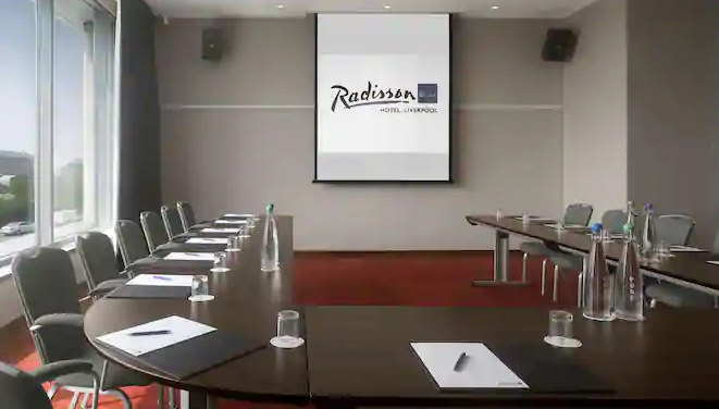 Modern meeting room at Radisson Blu, Liverpool, set for corporate event with oval table.