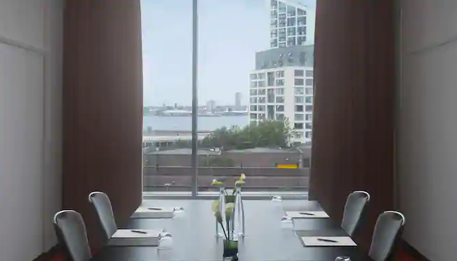 Modern meeting room at Radisson Blu Liverpool with large windows, perfect for conferences.