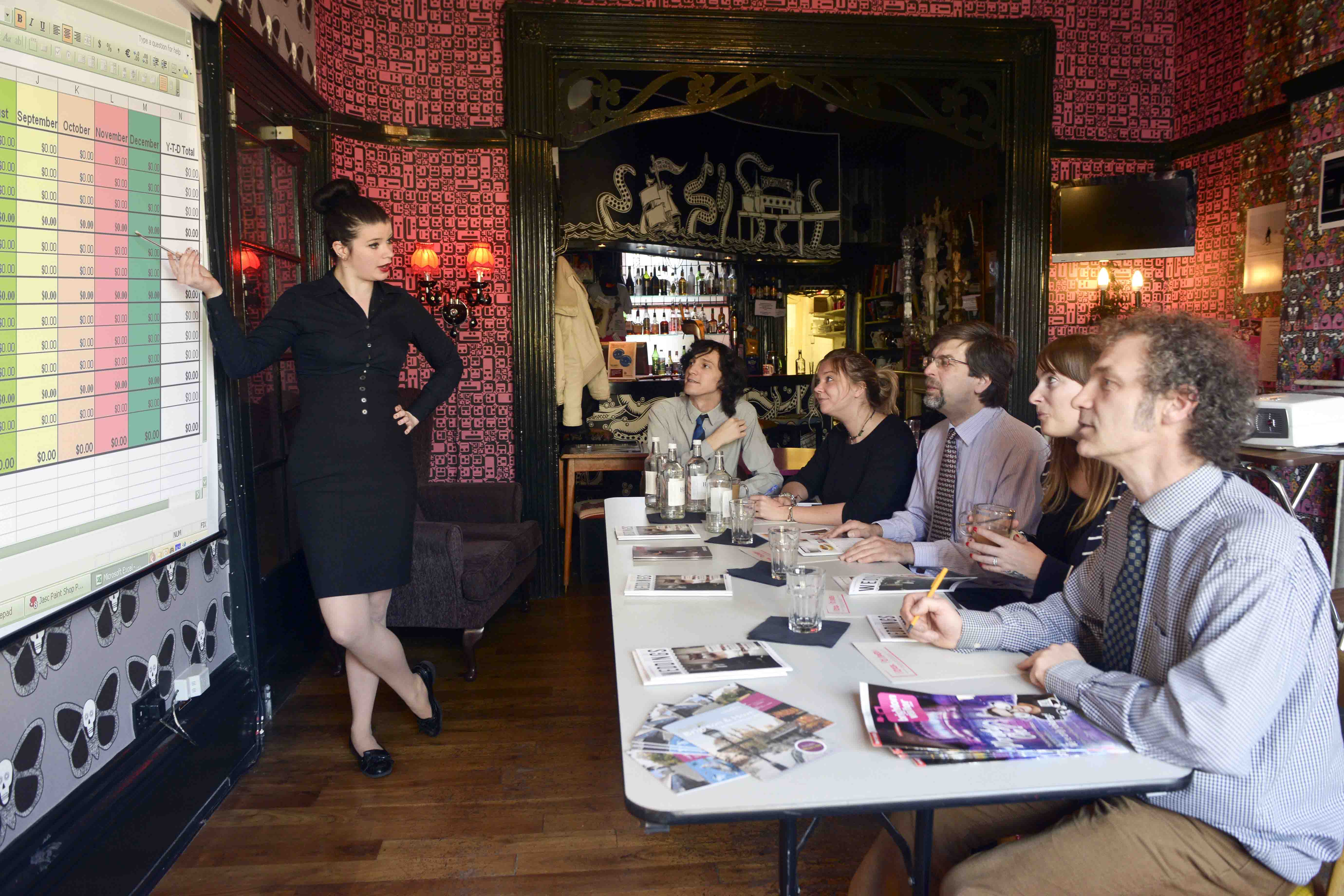 "Stylish hotel meeting room with presenter and engaged audience for creative brainstorming."