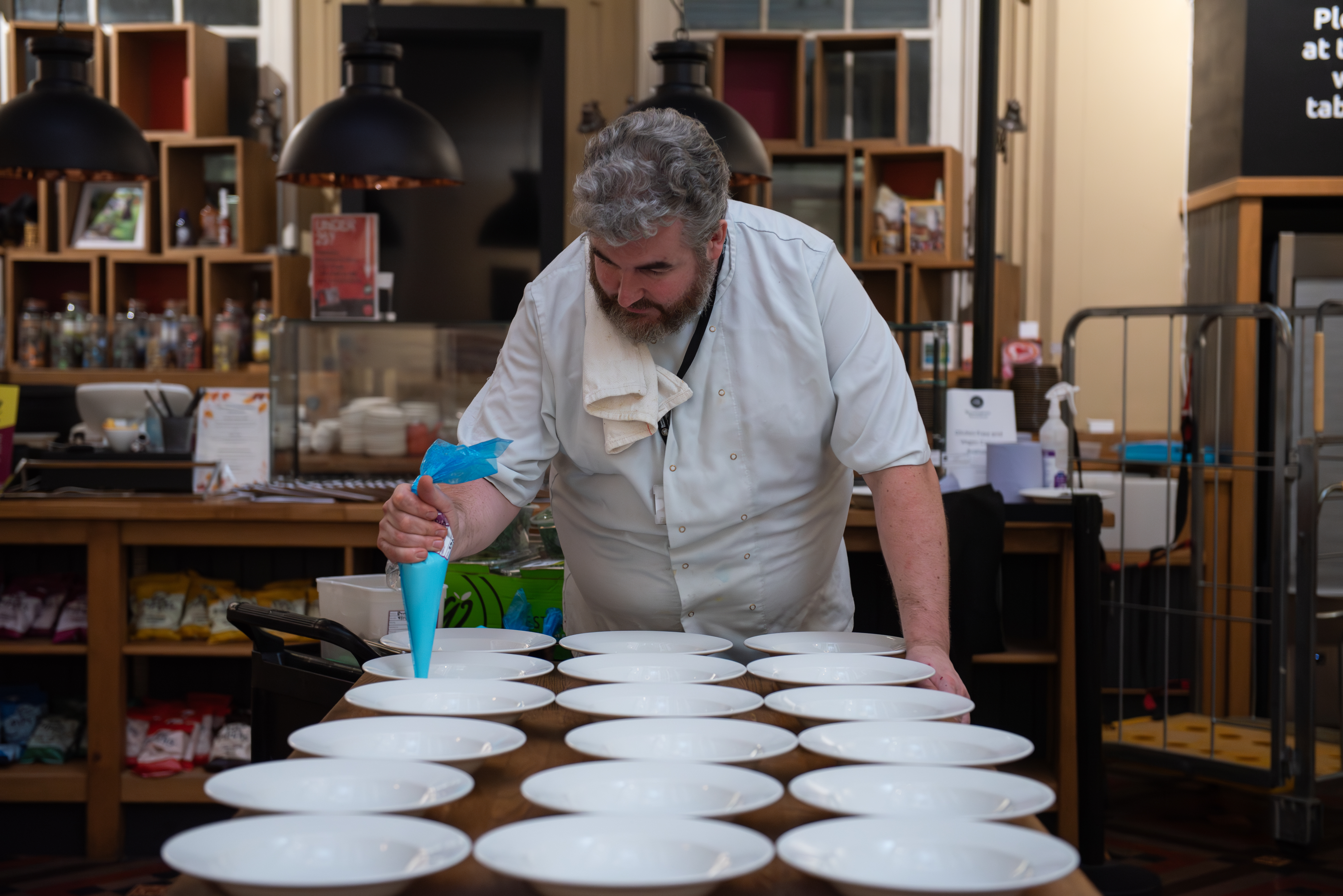 Culinary expert plating dishes at Birmingham Museum's Industrial Gallery event catering.