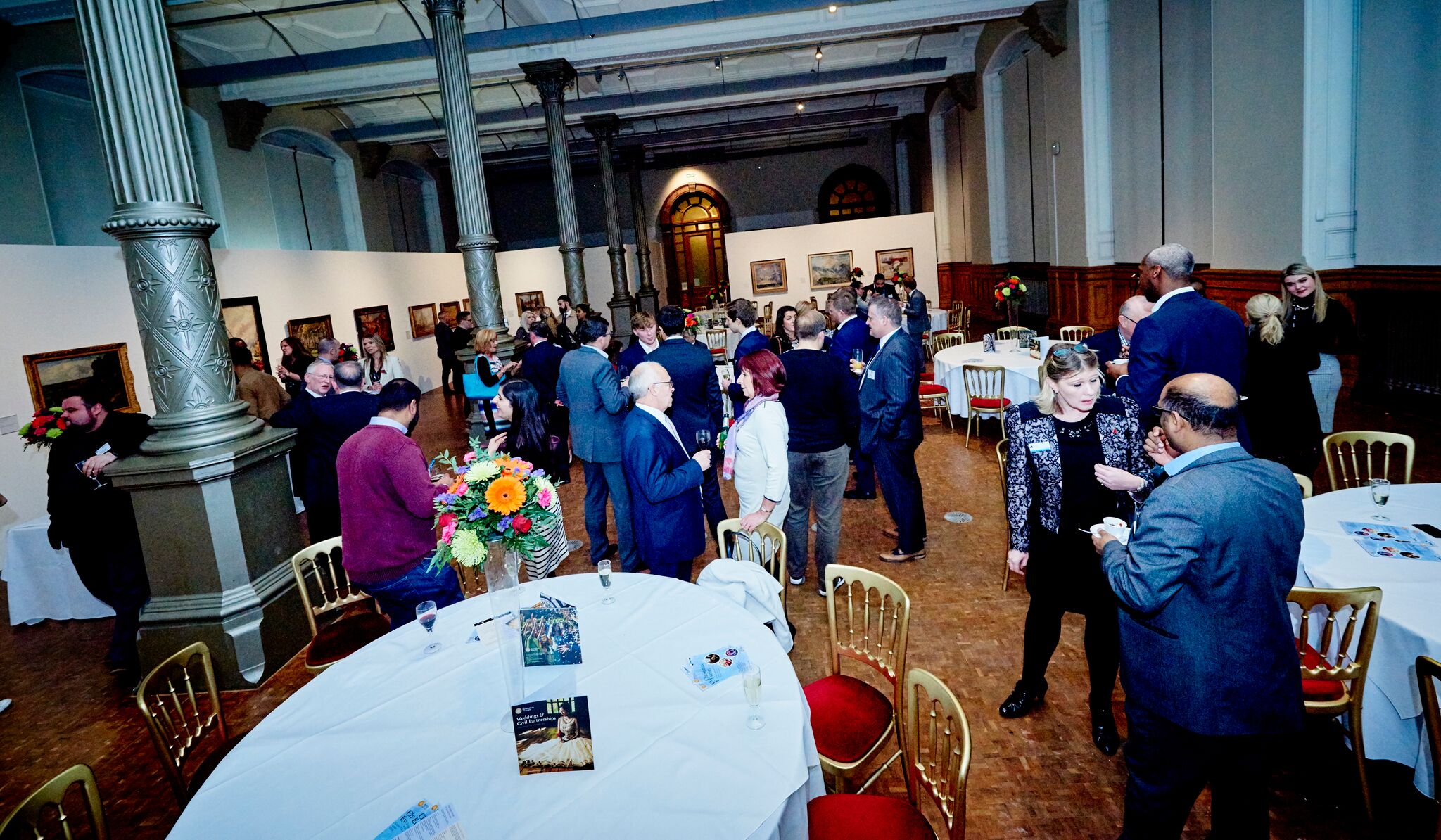 Vibrant networking event at Waterhall, Birmingham Museum; elegant tables and art decor.