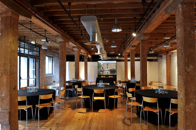 Rum Store event space in London Docklands, featuring round tables and industrial design.