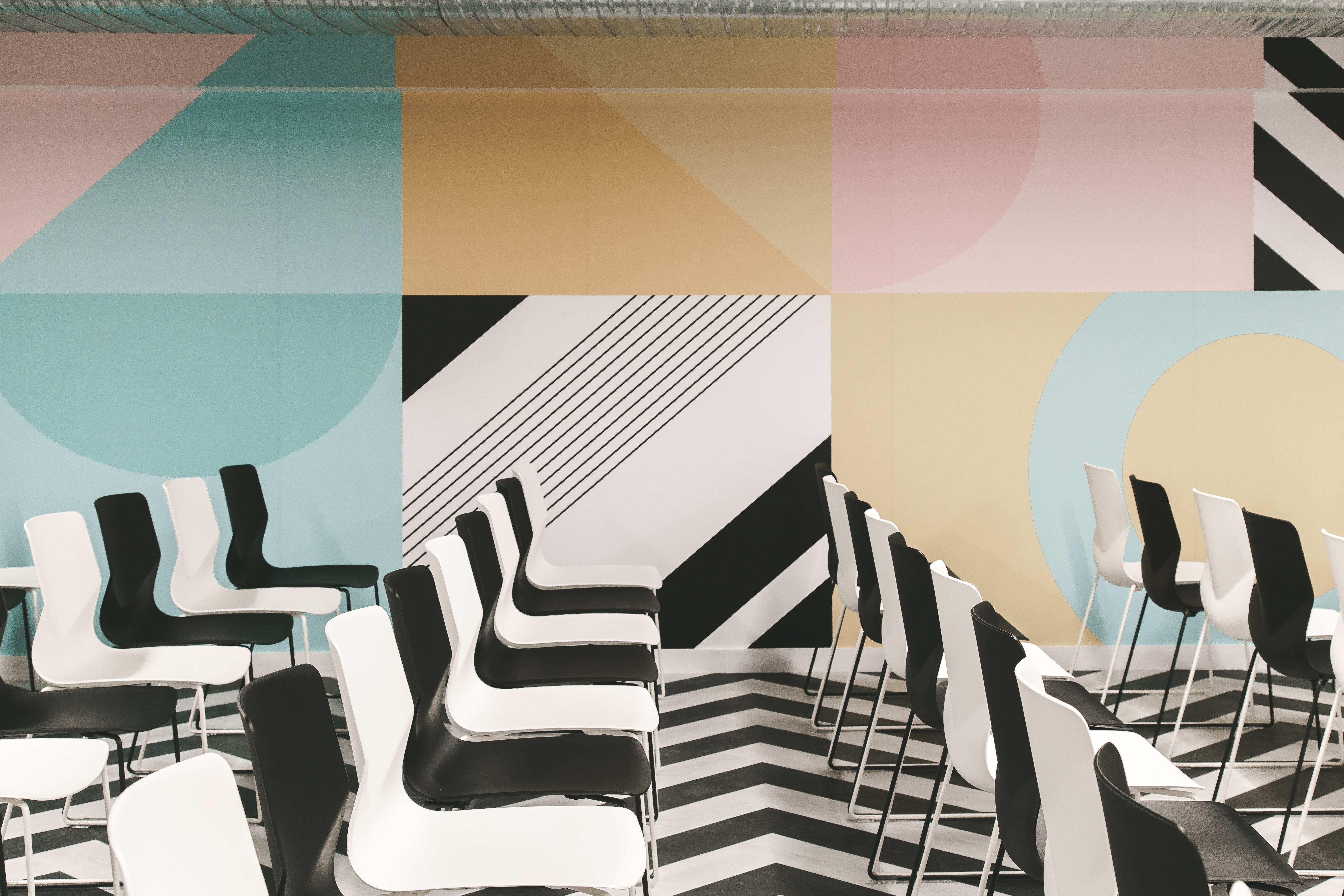 Modern event space in Huckletree Ancoats with vibrant geometric wall design.