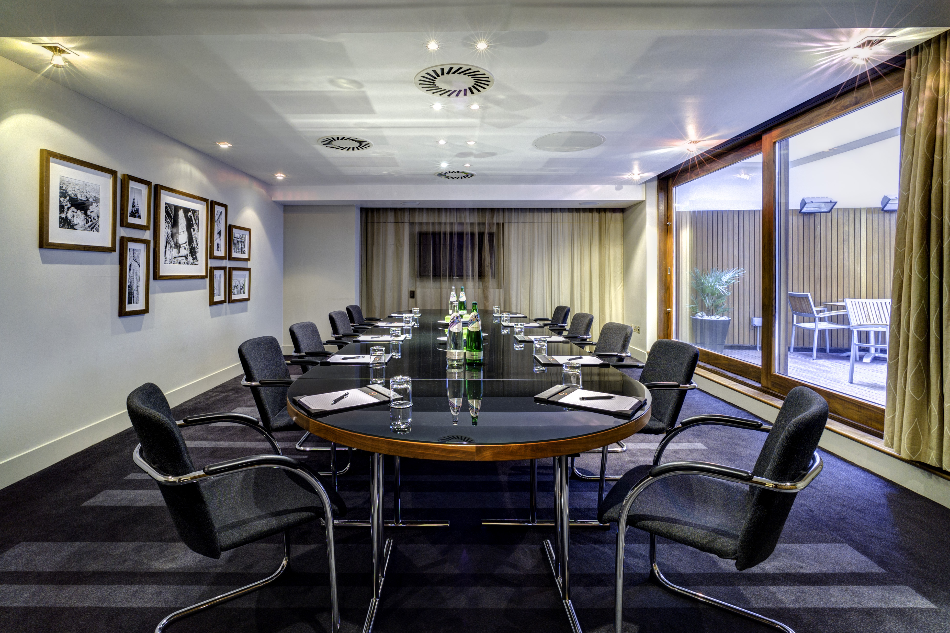 Modern meeting room in Apex City of London Hotel, featuring a sleek oval table and natural light. - Banner