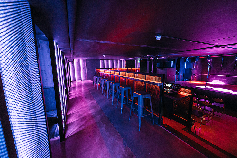 Modern event space in Peckham Audio with vibrant bar and ambient lighting.