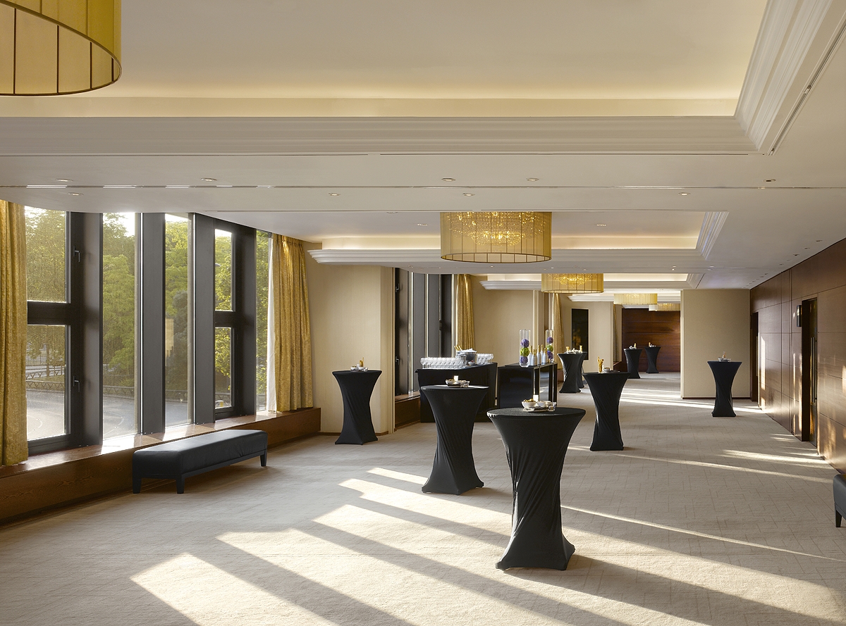 Elegant ballroom reception London, high-top tables, natural light.