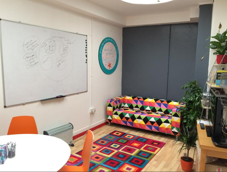Vibrant meeting room with colorful couch for creative team workshops and brainstorming.