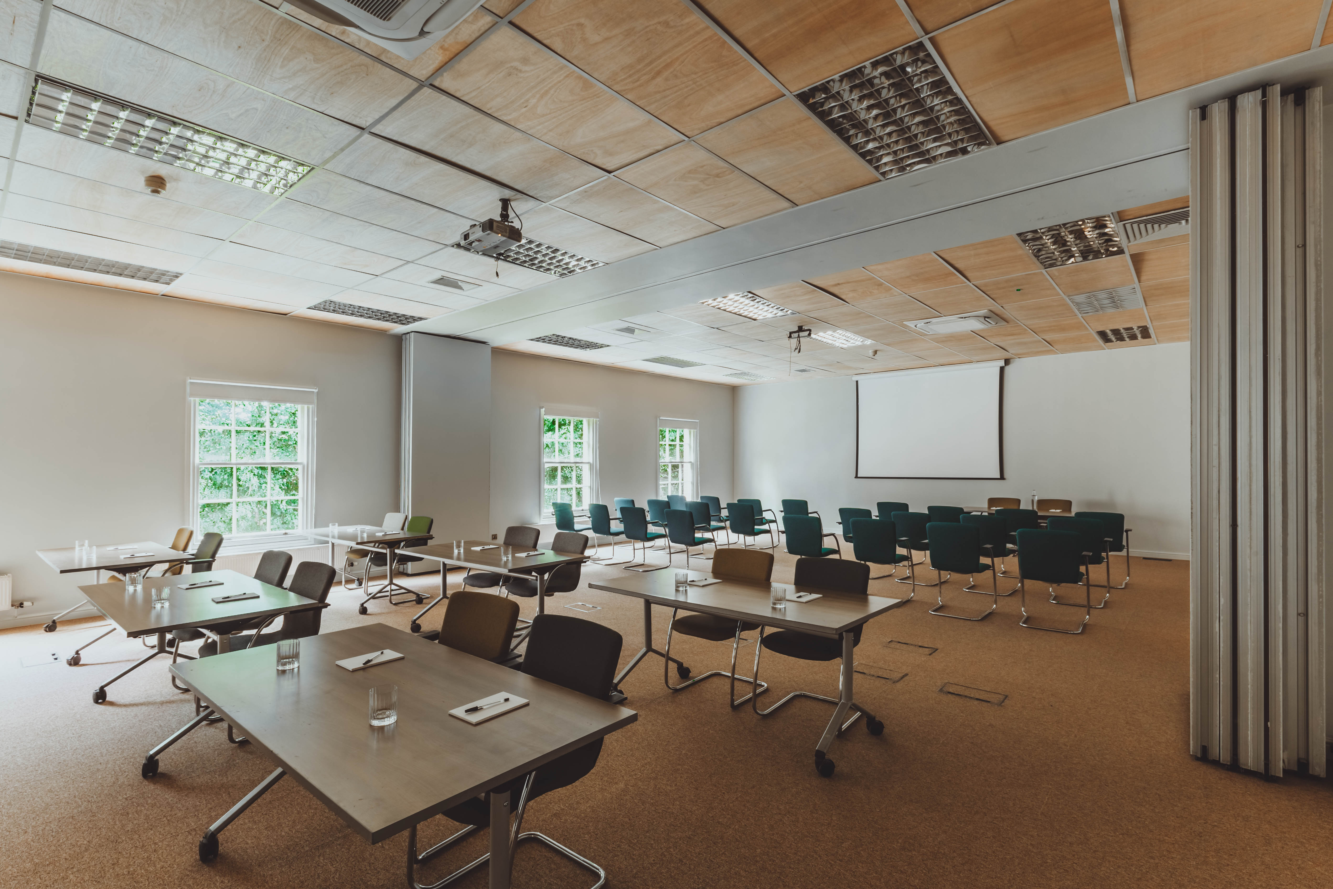 Versatile meeting space with natural light, ideal for workshops and seminars.
