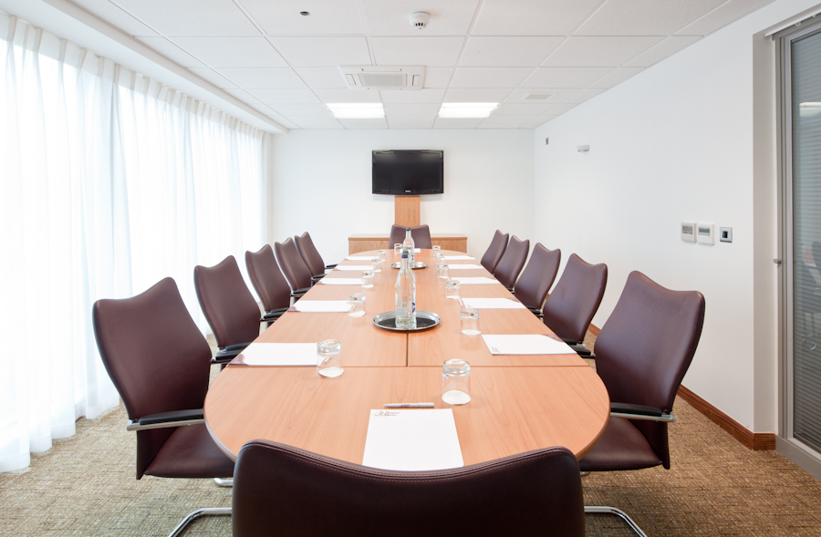 Modern conference room with polished table, ideal for professional meetings and presentations.