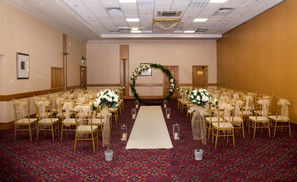 Elegant wedding ceremony setup with floral arch at Britannia Hotel Newcastle Airport.