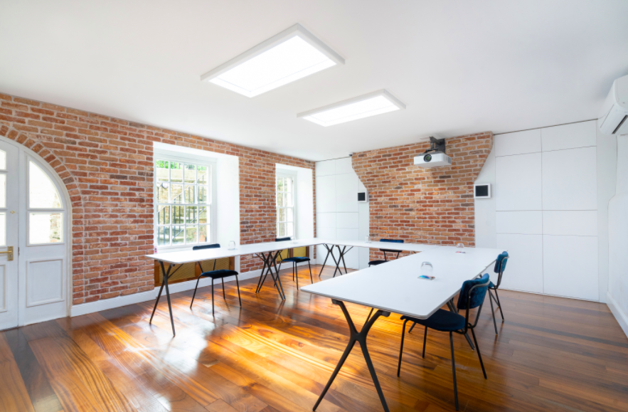 Abraham Room in Square Works: modern rustic meeting space with exposed brick, ideal for workshops.
