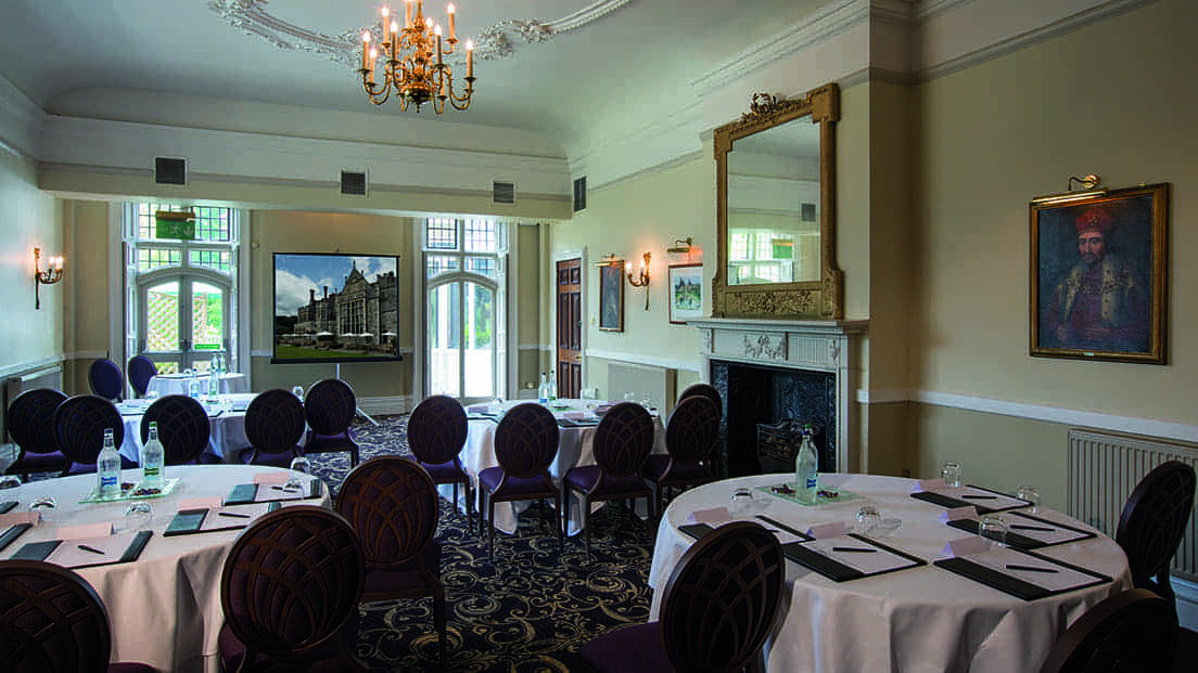 Sophisticated meeting room at Rhinefield House Hotel with elegant round tables for corporate events.