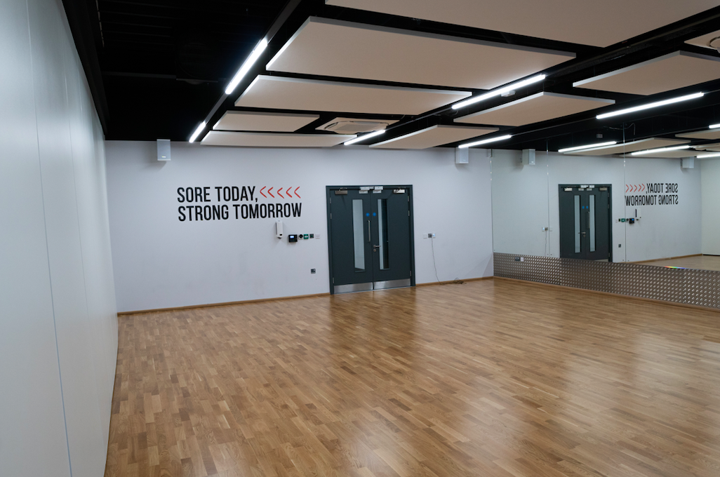 Dance studio with polished wooden floor, ideal for workshops and fitness classes.