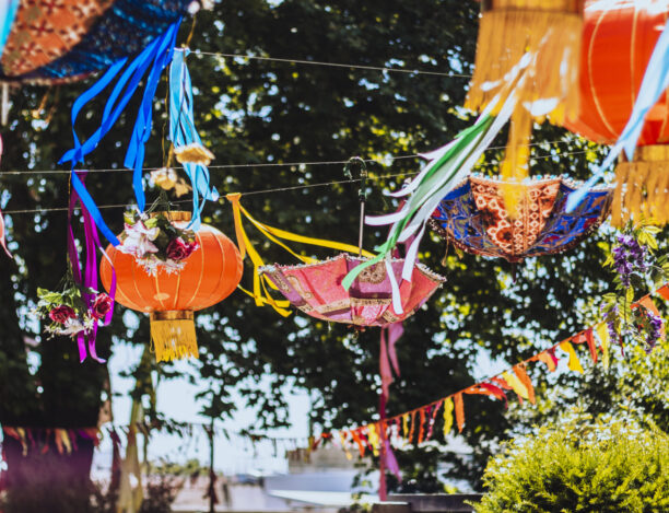 Vibrant outdoor event space with colorful lanterns for weddings and festivals. - Banner