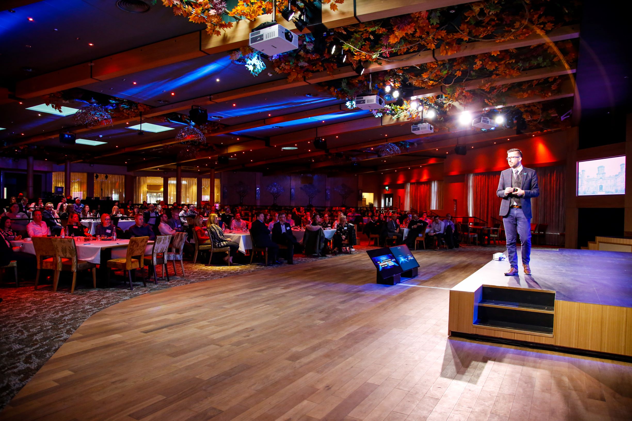 Elegant event space at Studley Castle with speaker addressing engaged audience. Conference setup. - Banner