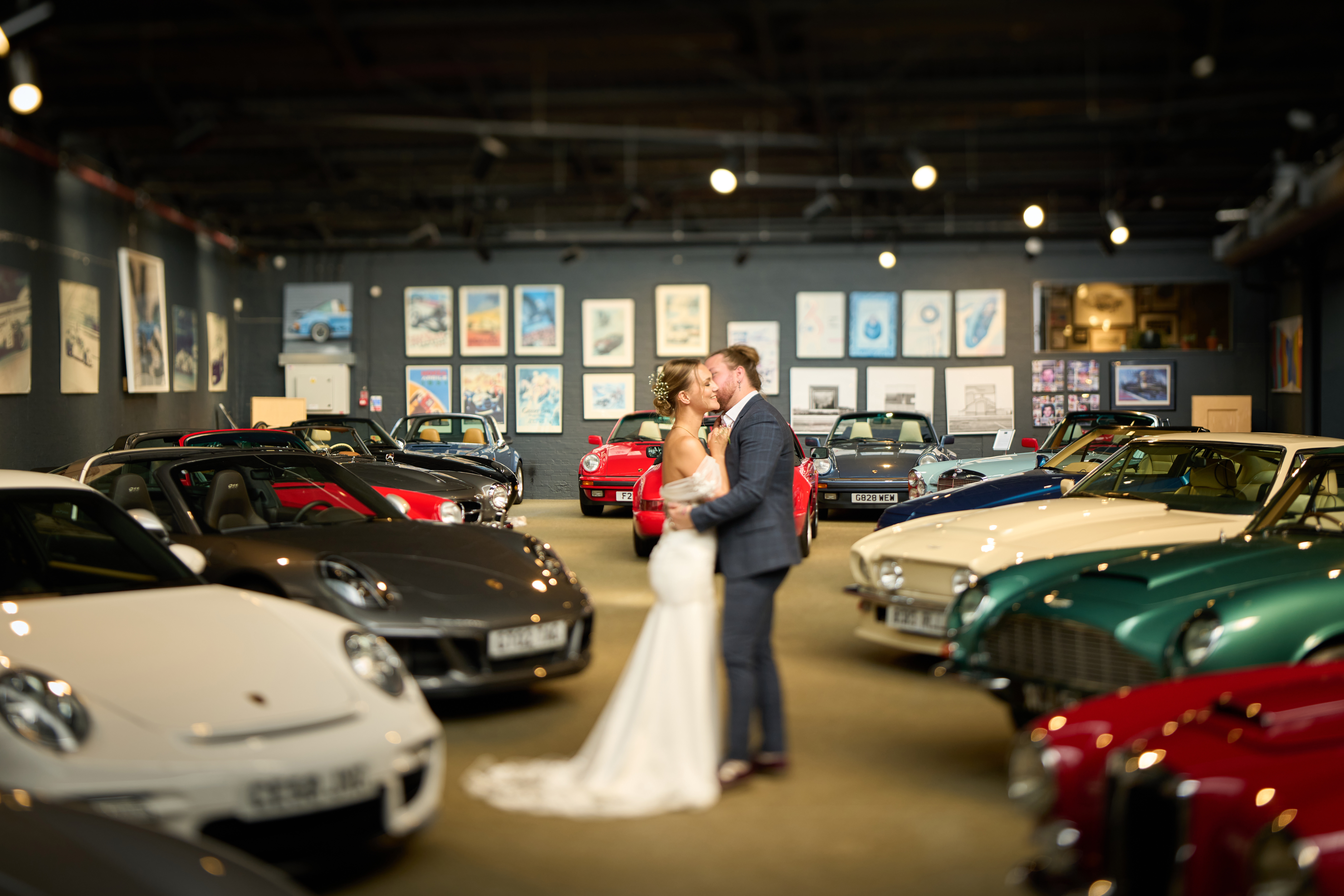 Elegant wedding venue in upscale car gallery with classic cars backdrop. - Banner