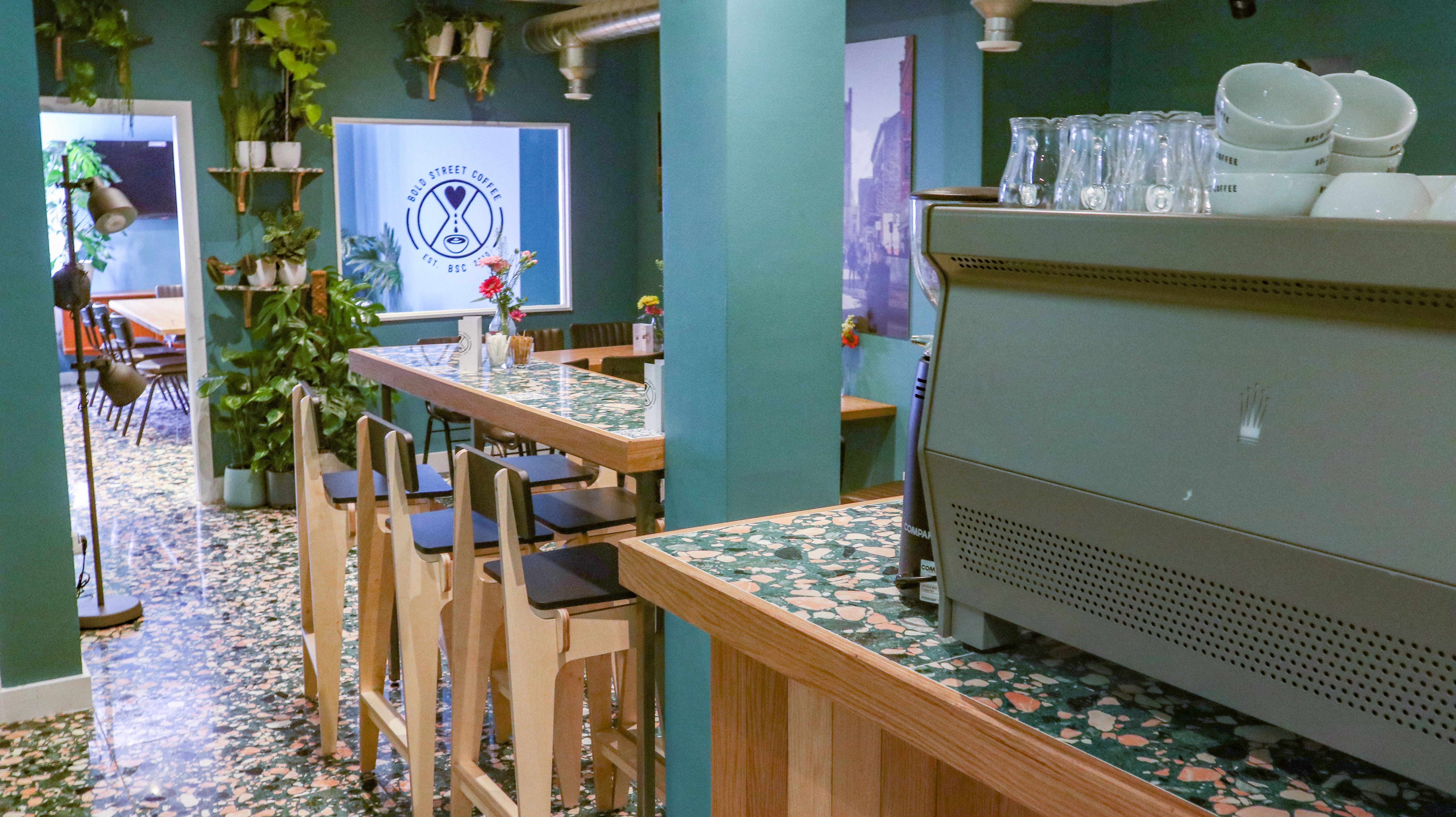 Event space at Bold Street Coffee Liverpool with modern bar and lush greenery for gatherings.