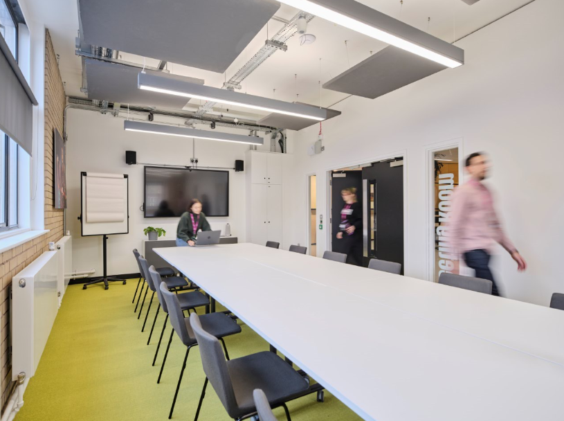 Modern meeting room with long table, ideal for collaboration and presentations.
