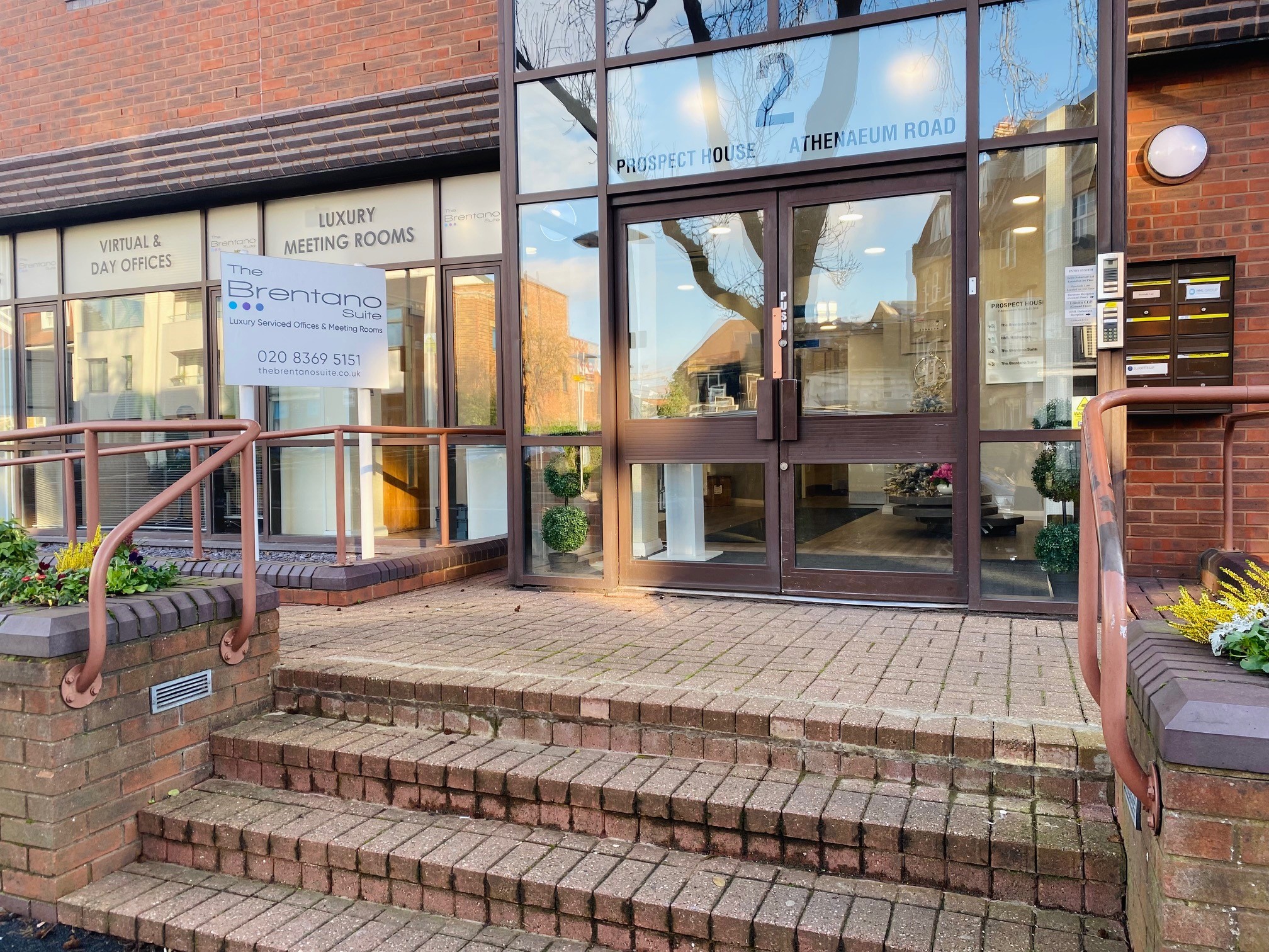 Modern entrance of Prospect House, luxury meeting venue with elegant greenery. - Banner
