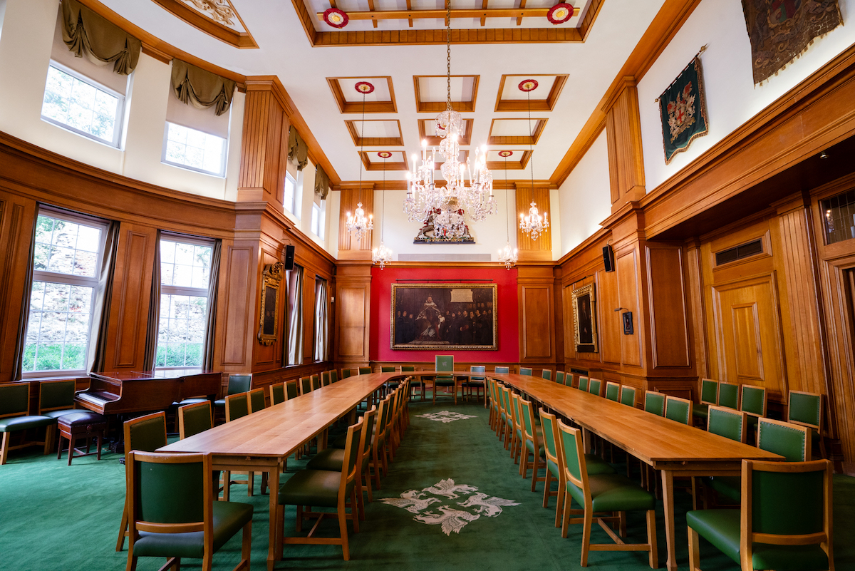 Great Hall in Barber-Surgeons’ Hall with wooden paneling, ideal for formal events and meetings.