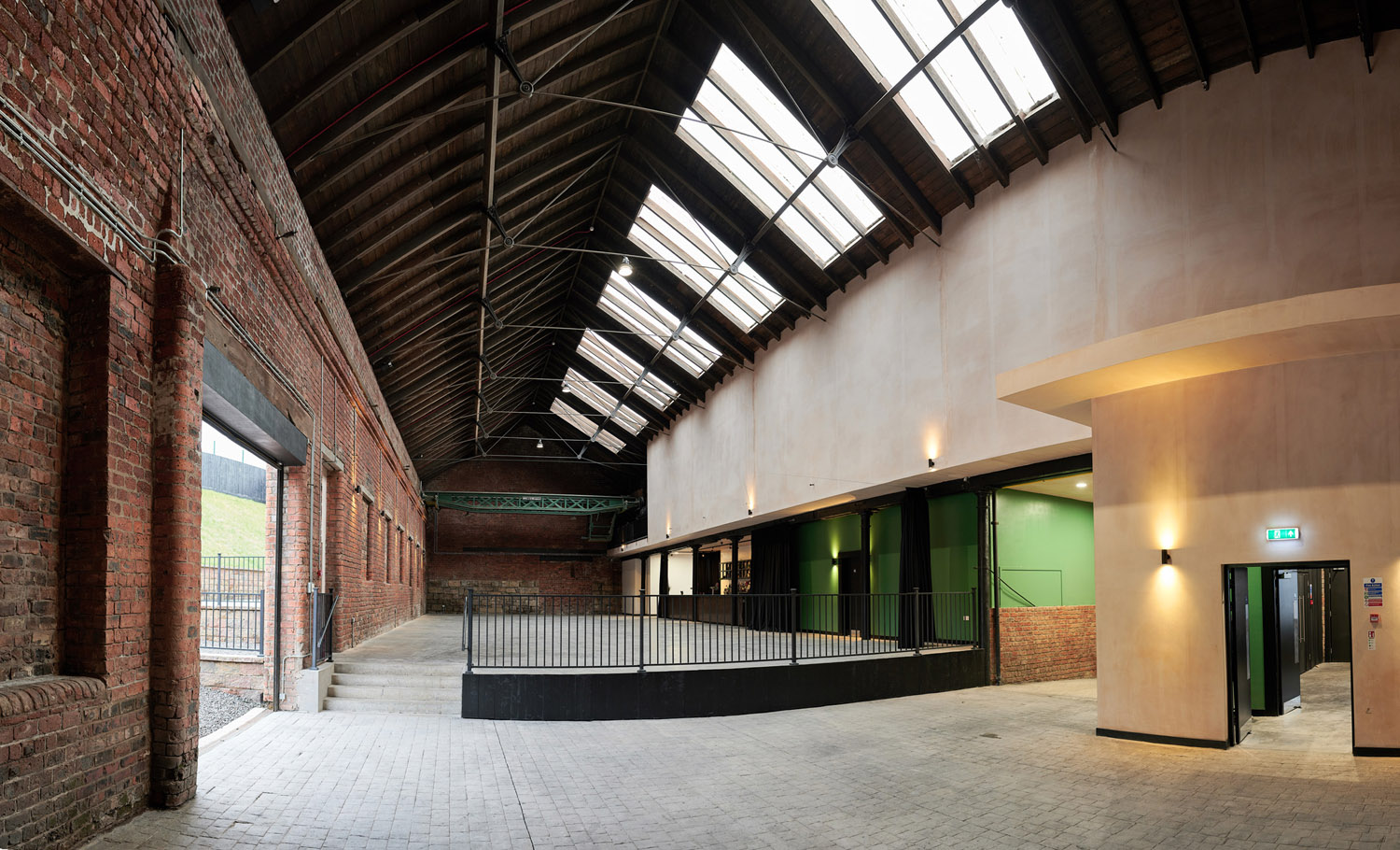 Spacious industrial venue with high ceilings for conferences and workshops.