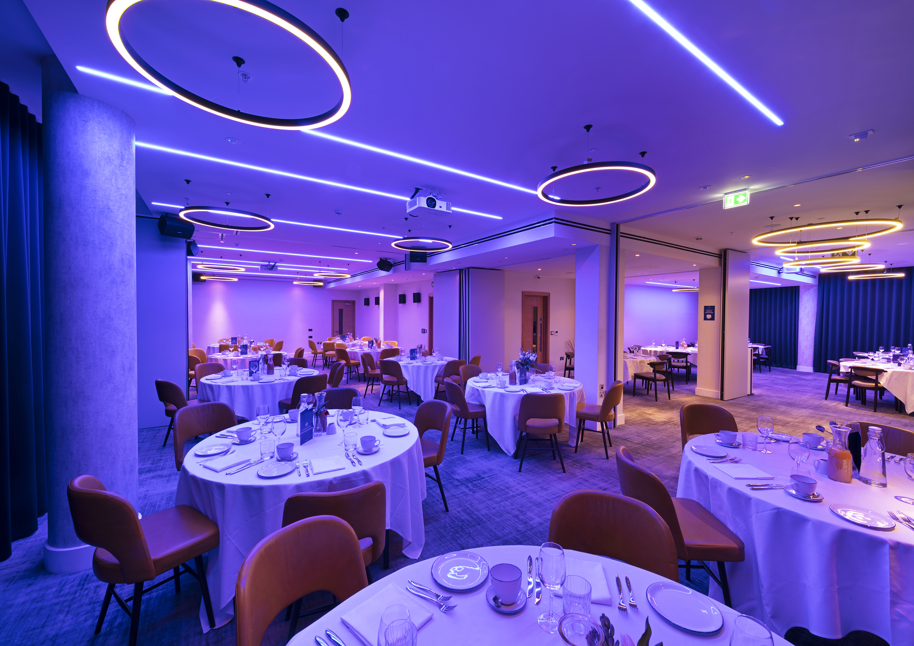 Royal Suite event space with elegant round tables and ambient purple lighting. - Banner