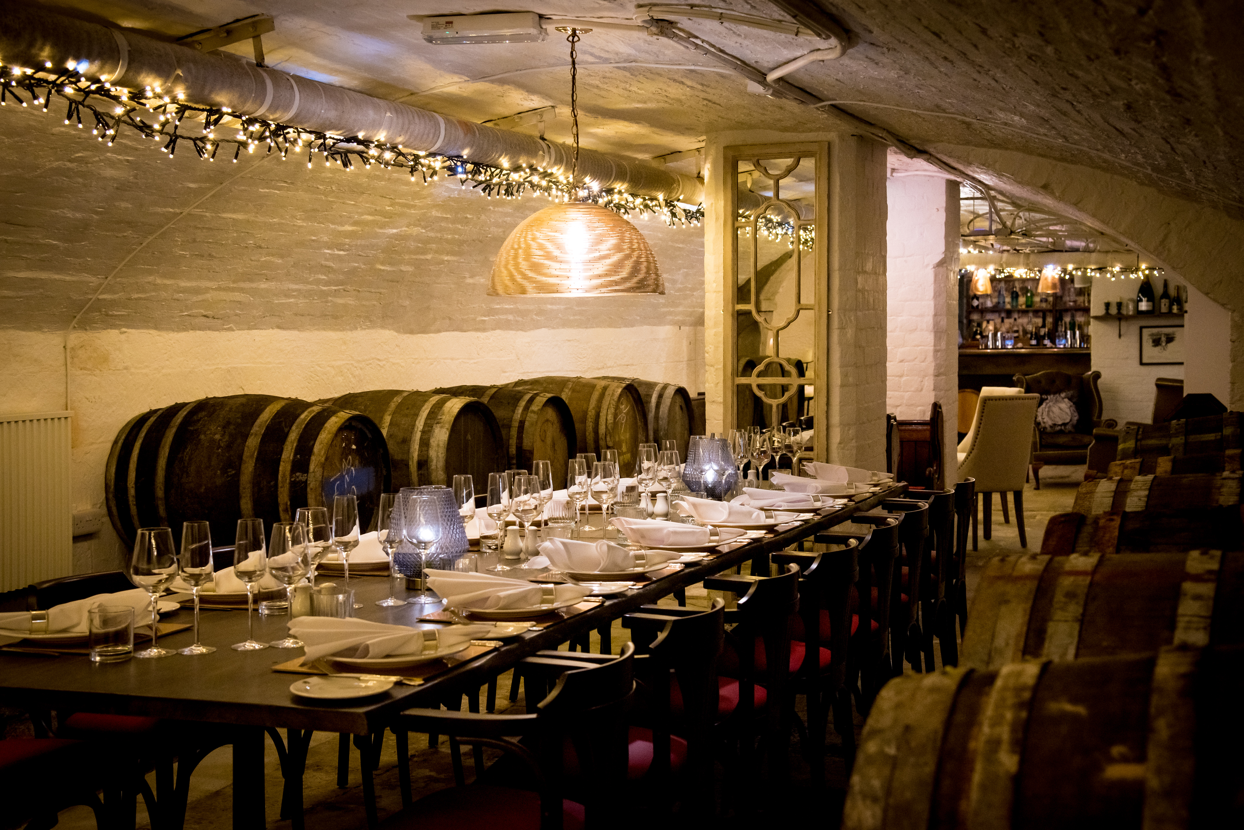 Elegant dining setup in rustic wine cellar for intimate gatherings and wine tastings.
