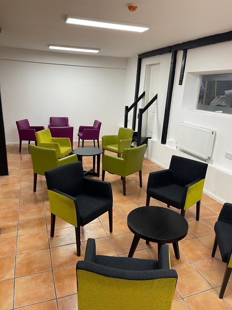 Modern Kingdom Hall meeting space with vibrant purple and green seating for gatherings. - Banner