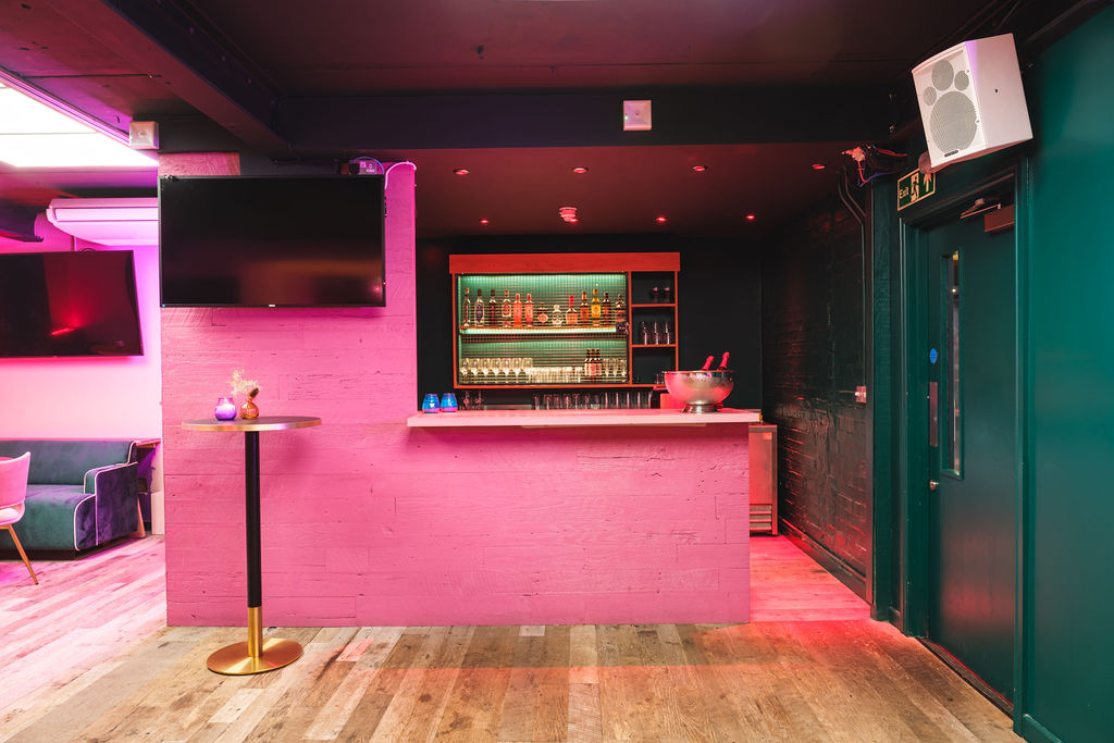 Modern bar at The Glam Palace, vibrant lighting for events and gatherings. - Banner