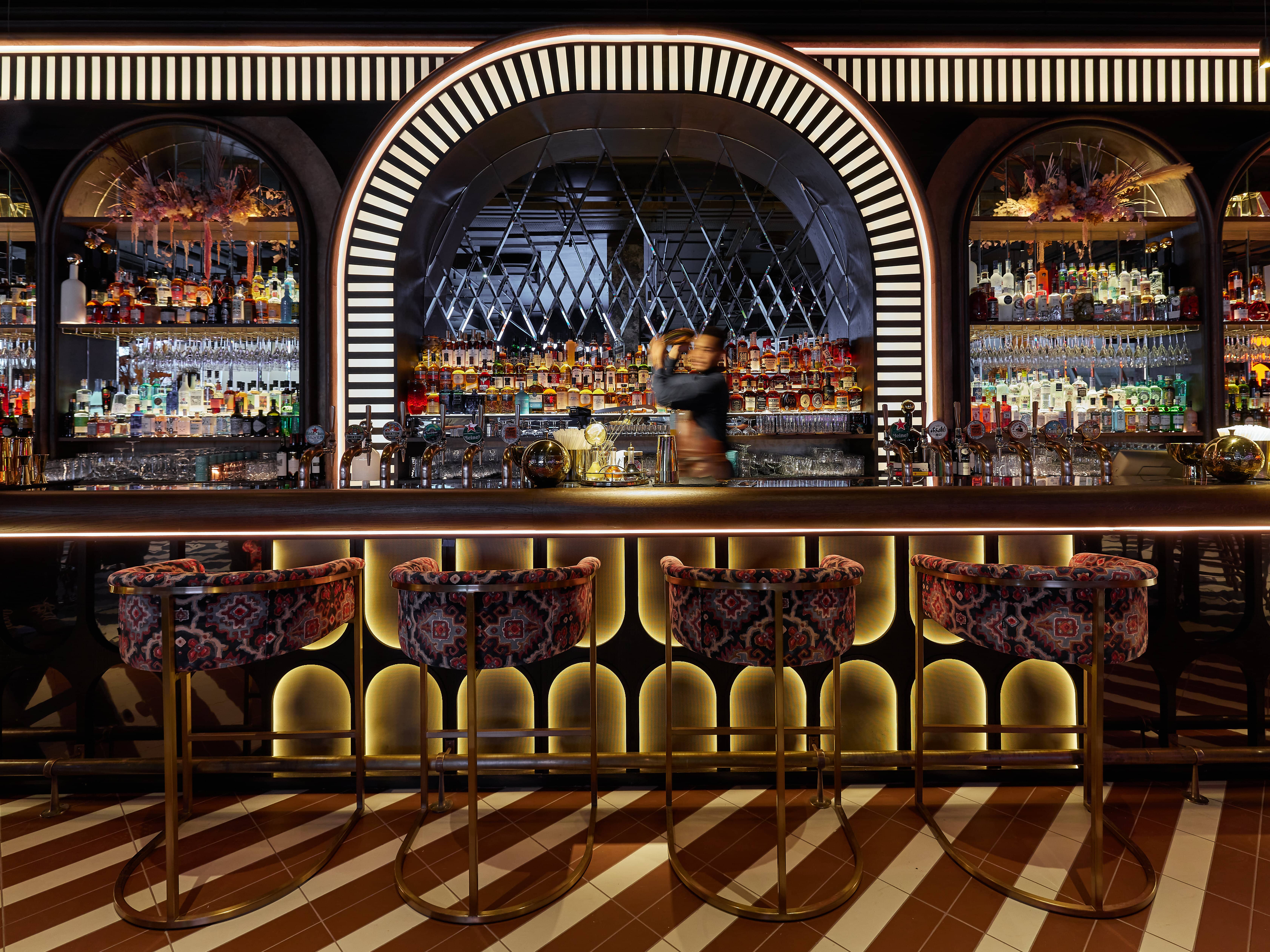 F1 Arcade venue with elegant bar, plush seating for networking events and cocktail receptions. - Banner