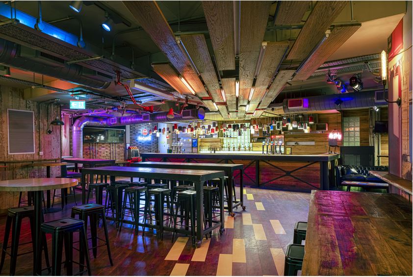 Main Bar at Shuffleboard London: modern event space with high tables for networking.