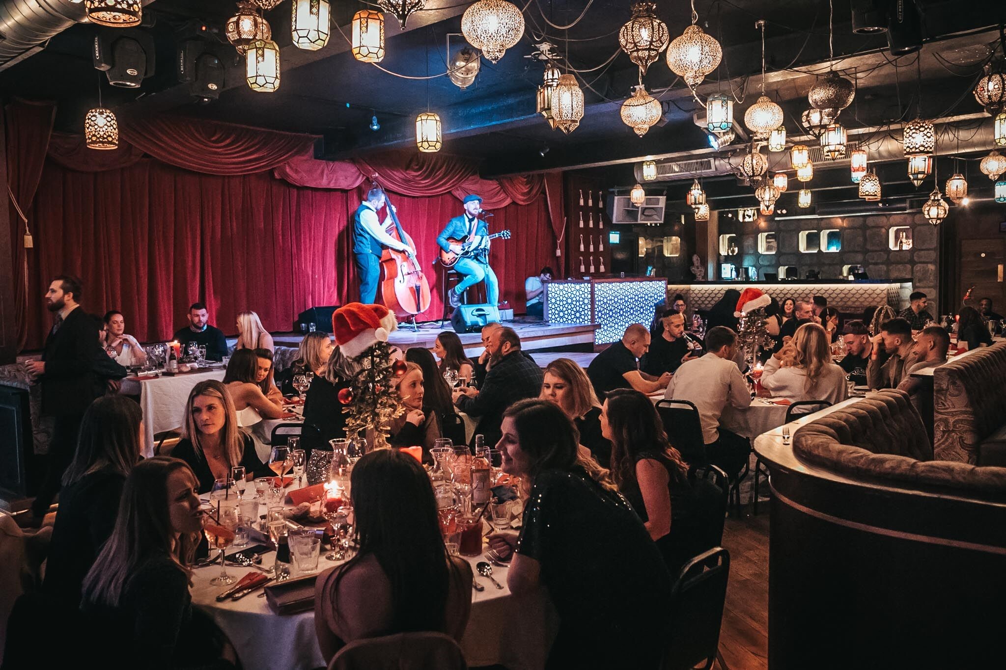 Vibrant Impossible Theatre event space with live performers and elegant dining setup. - Banner
