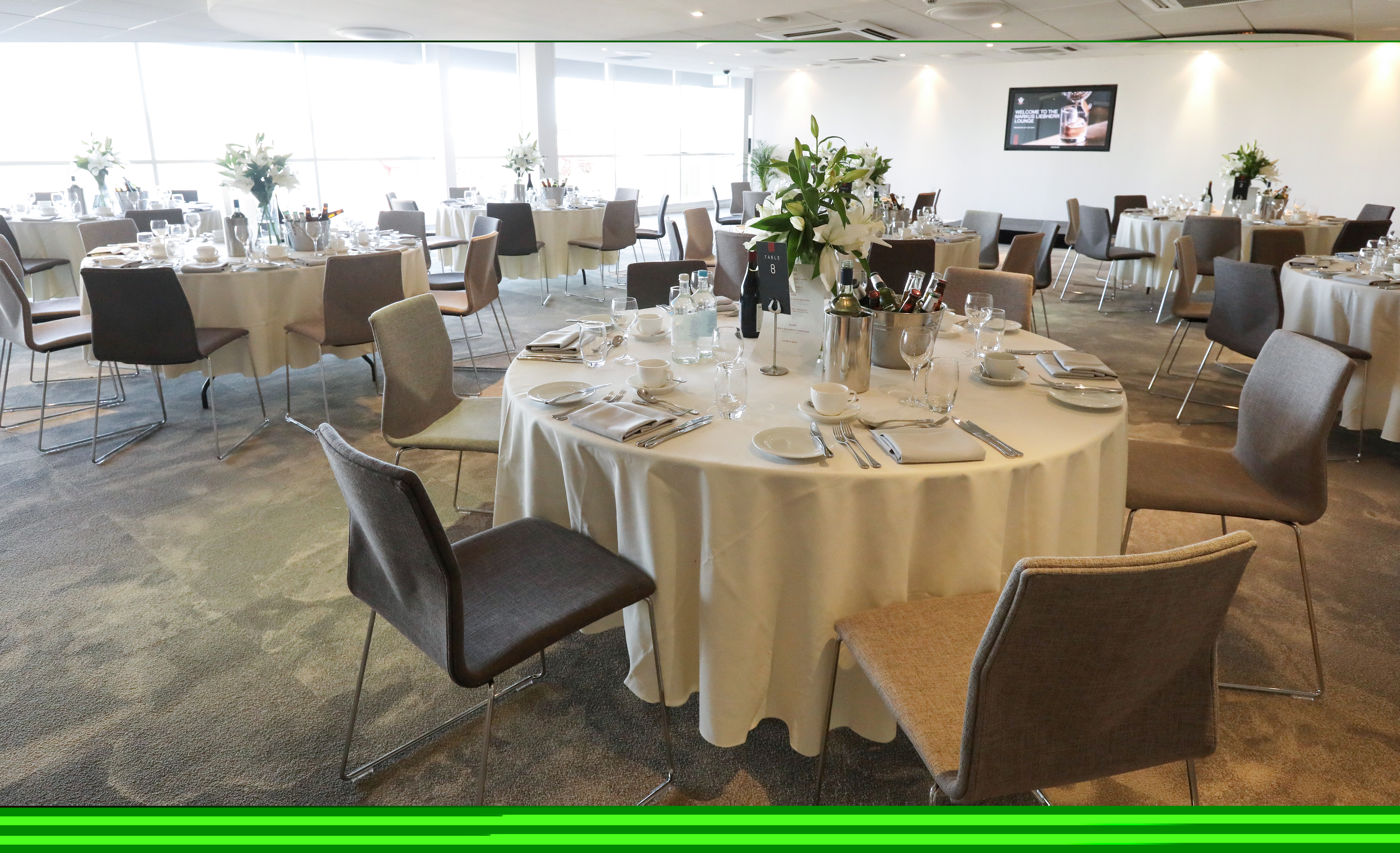 Markus Liebherr Lounge set for formal corporate event with elegant tables and floral centerpieces.