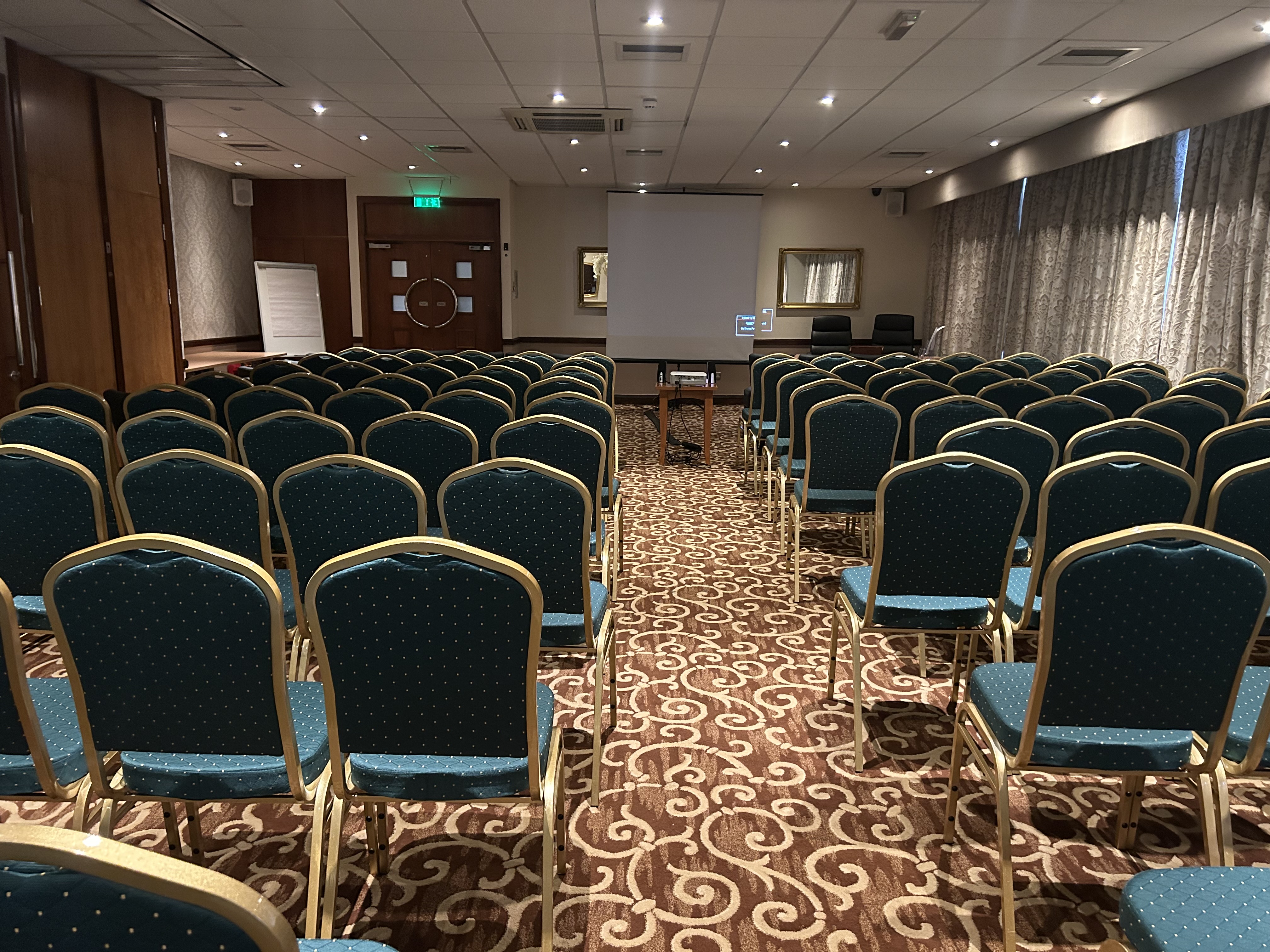 Bramhope Suite meeting room with green chairs, ideal for workshops and conferences.