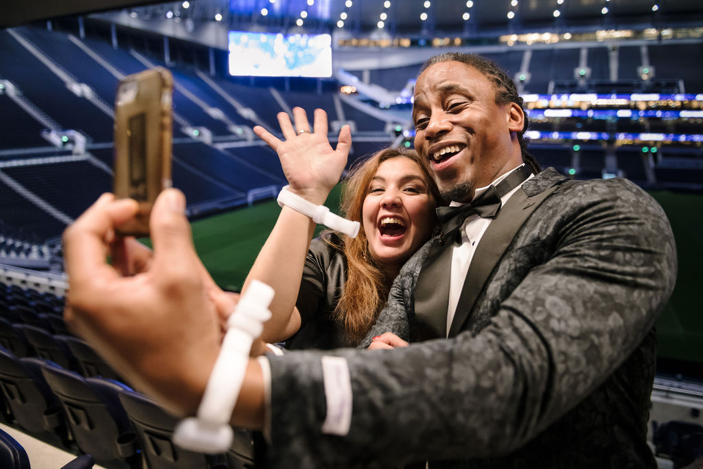 "Christmas party selfie at Tottenham Hotspur Stadium, vibrant event atmosphere."