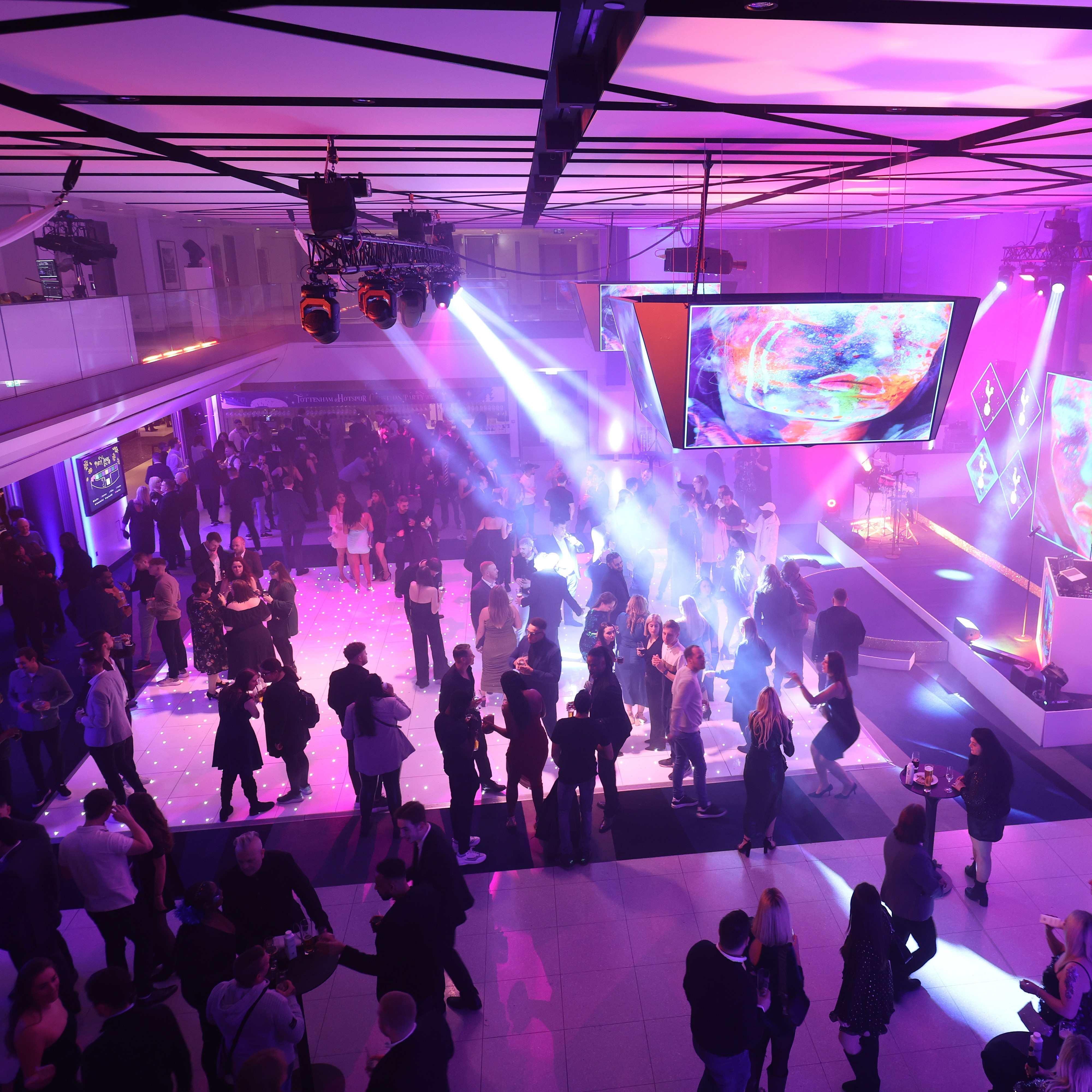 "Christmas party at Tottenham Hotspur Stadium with vibrant lighting and live DJ" - Banner