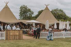 Elegant teepee tents set for upscale outdoor weddings and corporate events. - Banner