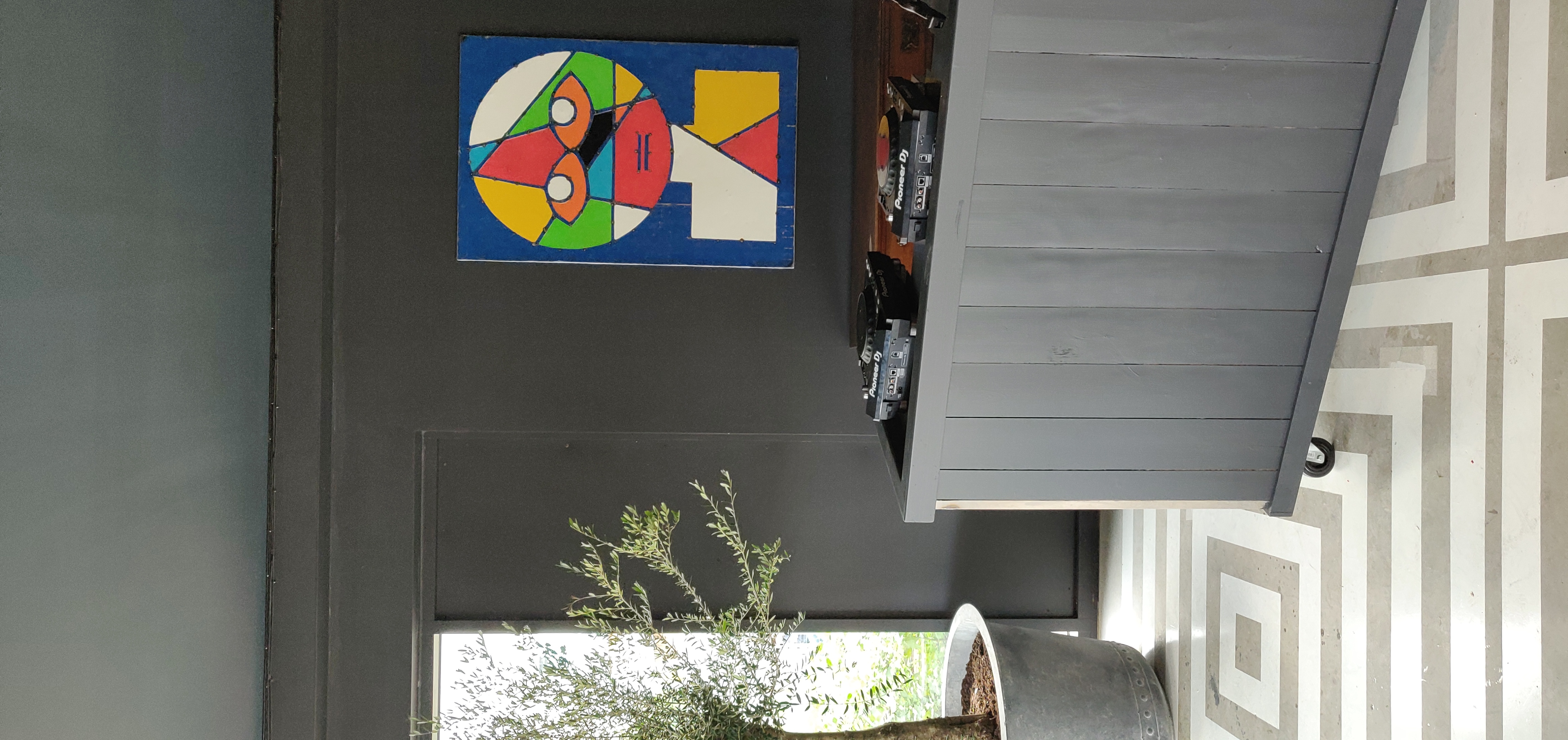 Stylish event space at Nico's Bar, Hackney Bridge, with DJ turntables and olive tree. - Banner