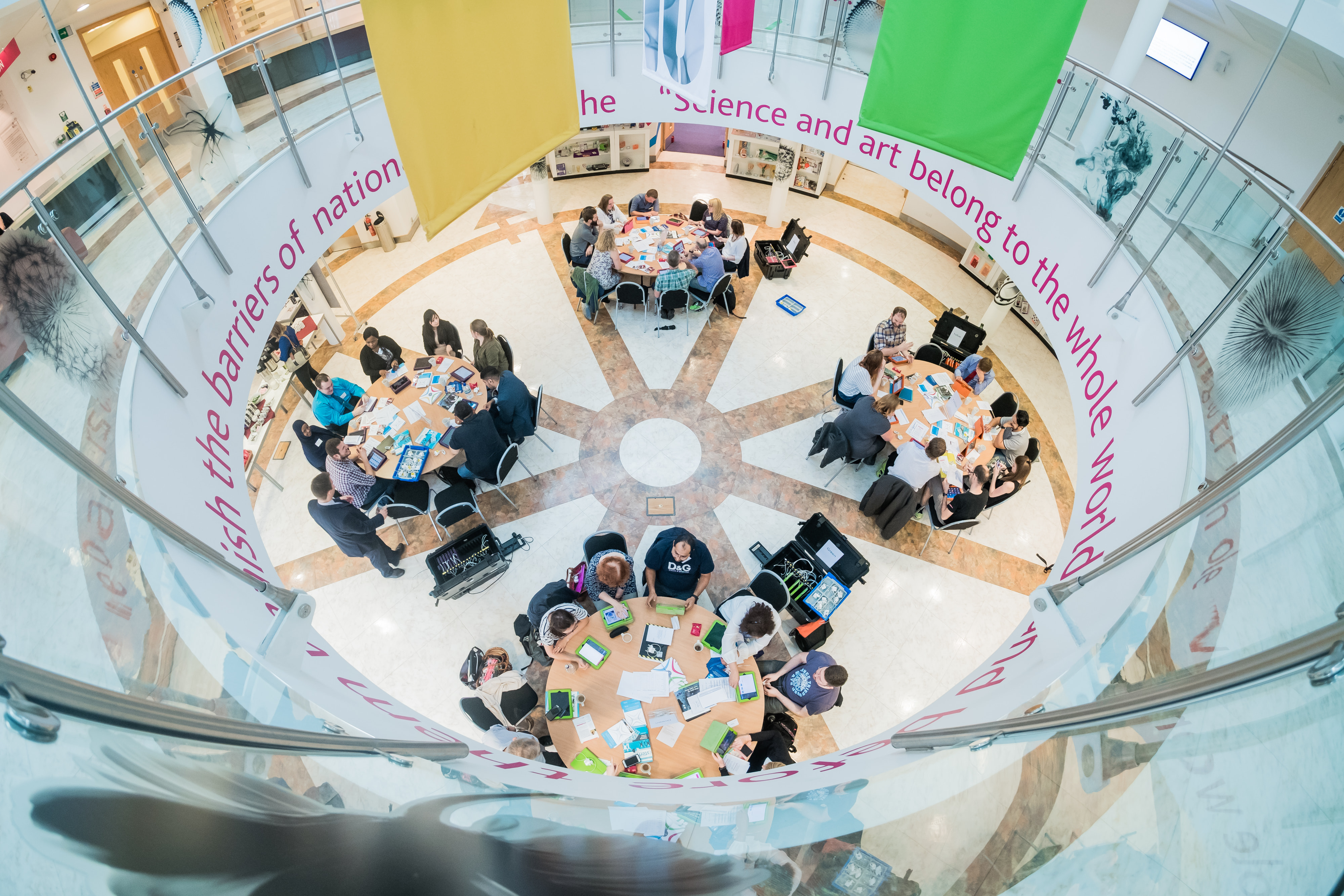 Vibrant meeting space with round tables at National STEM Learning Centre for workshops. - Banner