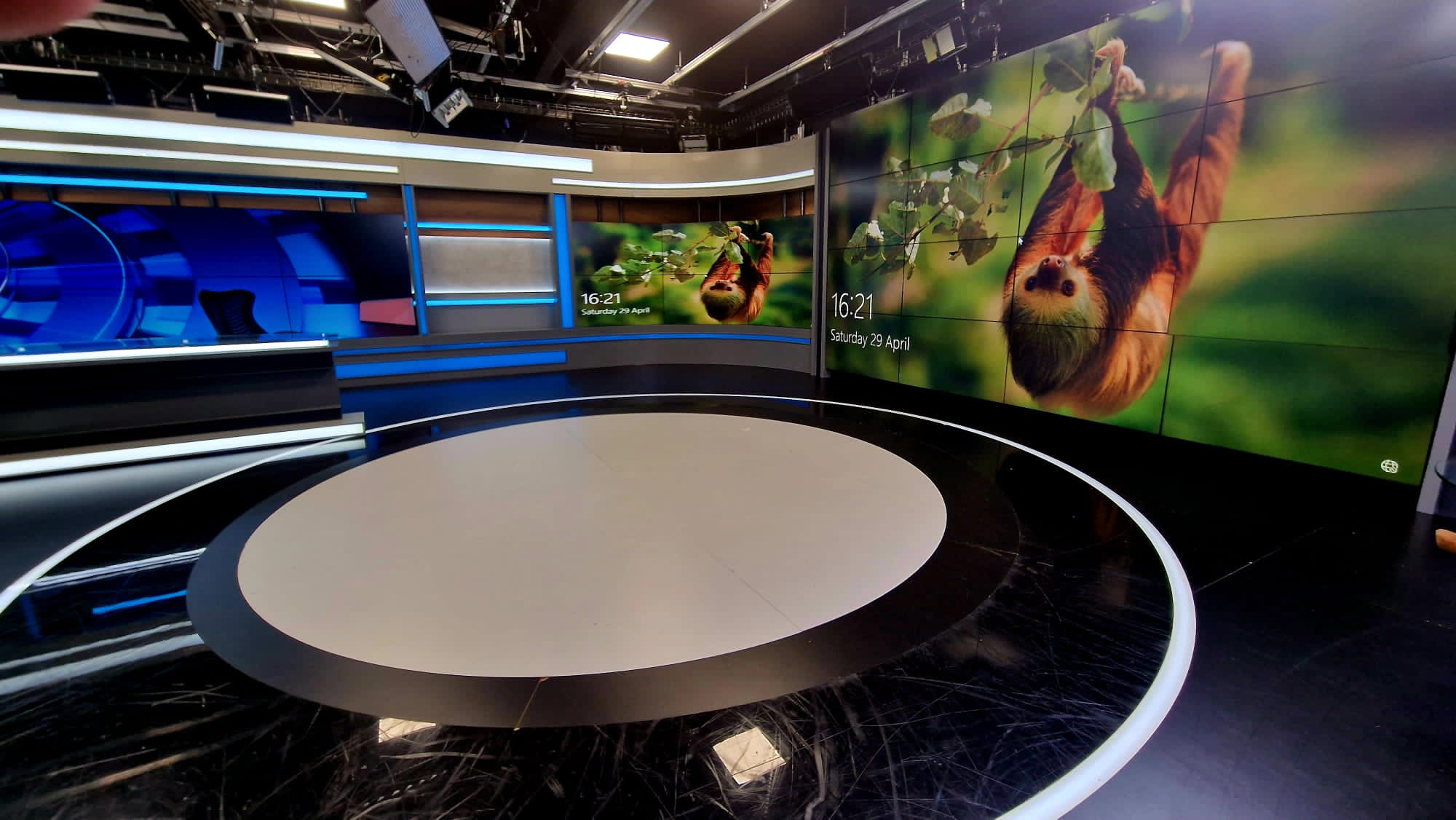 Modern event space with circular stage and digital screens for conferences and presentations.