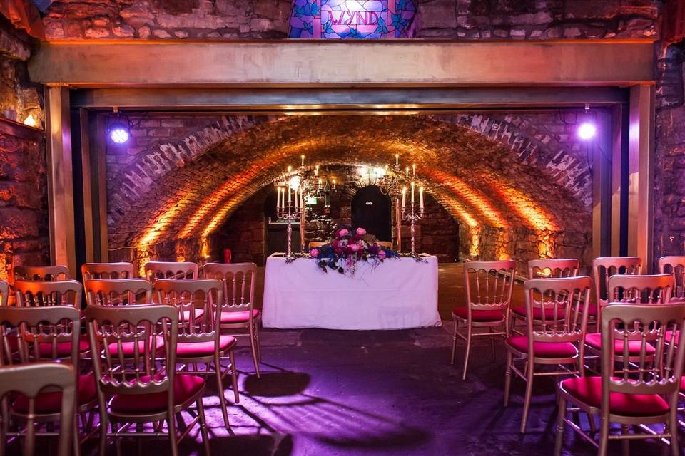 Vaulted Cellars event space with arched stone walls, ideal for weddings and gatherings. - Banner