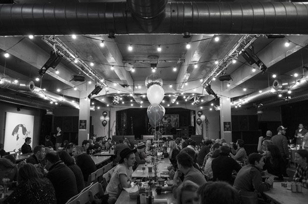 Vibrant photography studio event space with string lights, ideal for networking and gatherings. - Banner