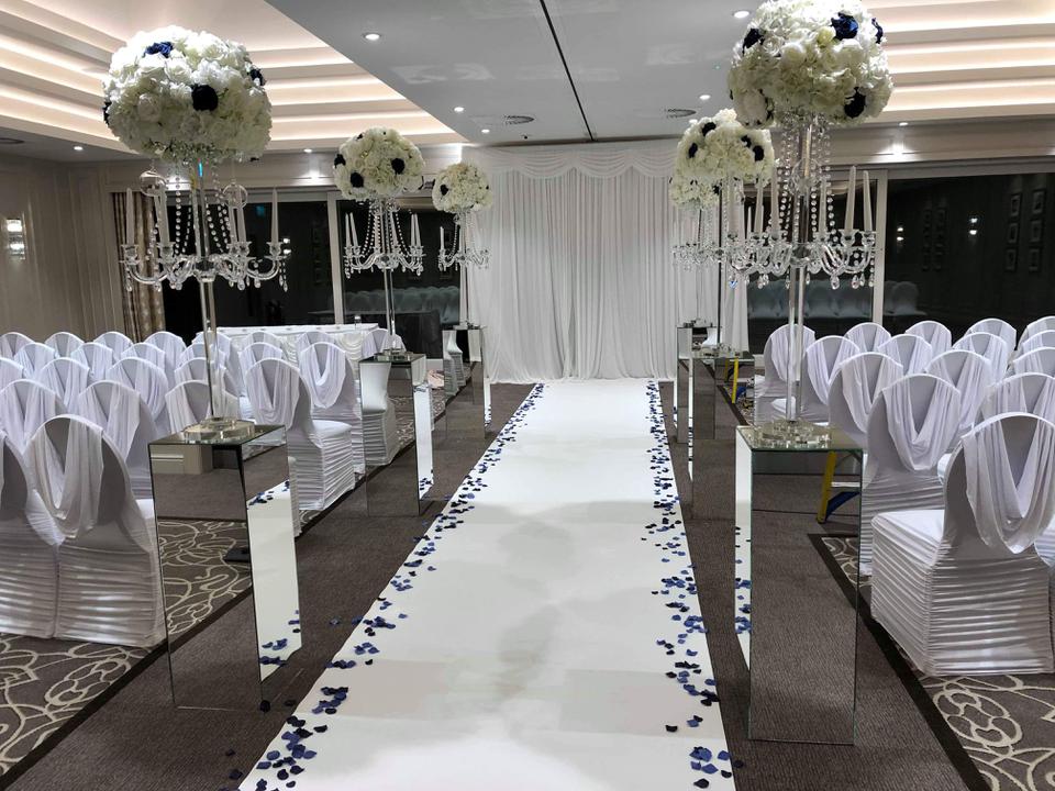 Elegant wedding event space with white chairs and floral centerpieces, ideal for gatherings.